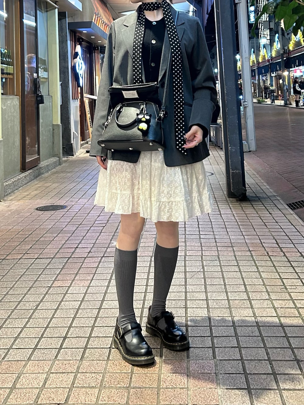 ブラック系のカーディガン/ボレロ、グレー系のテーラードジャケット、ブラック系のショルダーバッグを着用したレディースの秋コーディネートの1枚目の写真