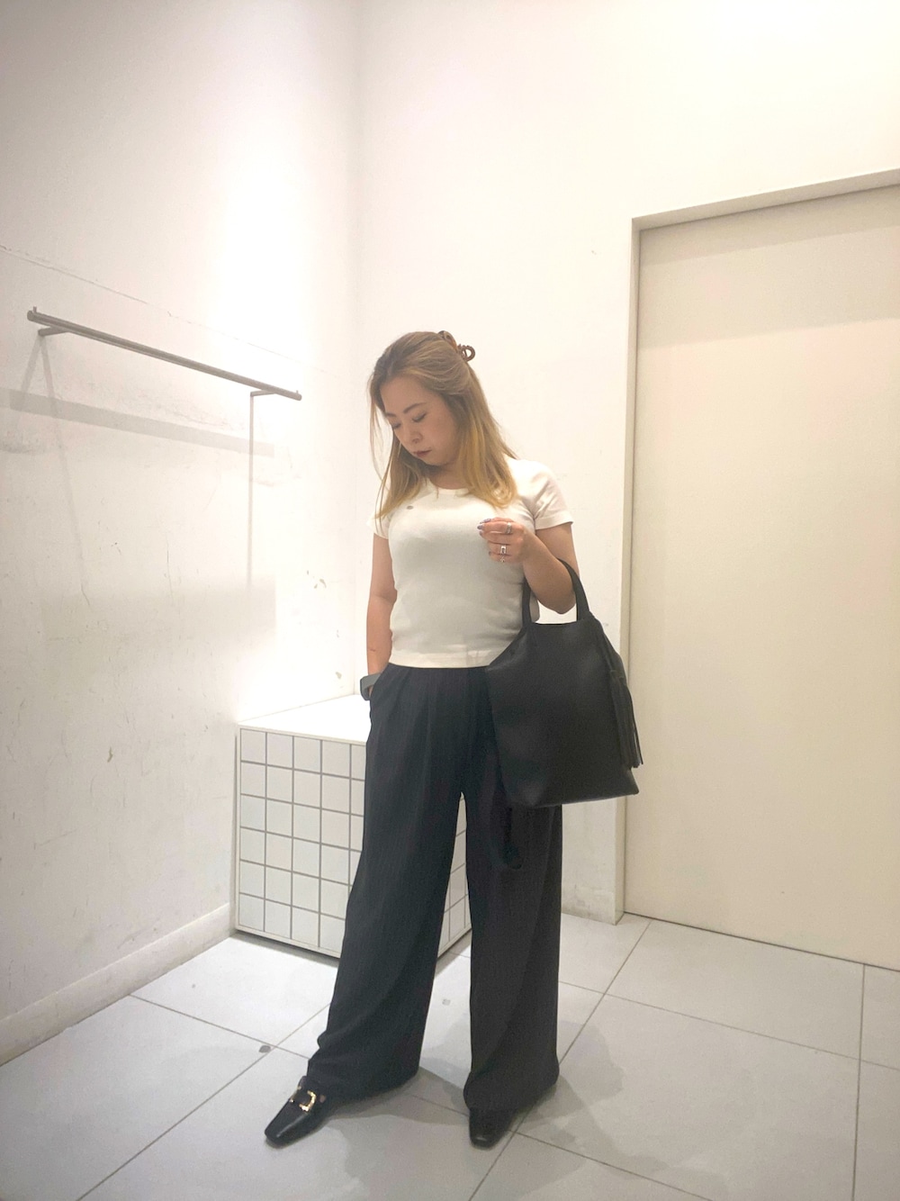 ホワイト系のTシャツ/カットソー、グレー系のスラックス、ブラック系のトートバッグを着用したレディースの夏コーディネートの1枚目の写真