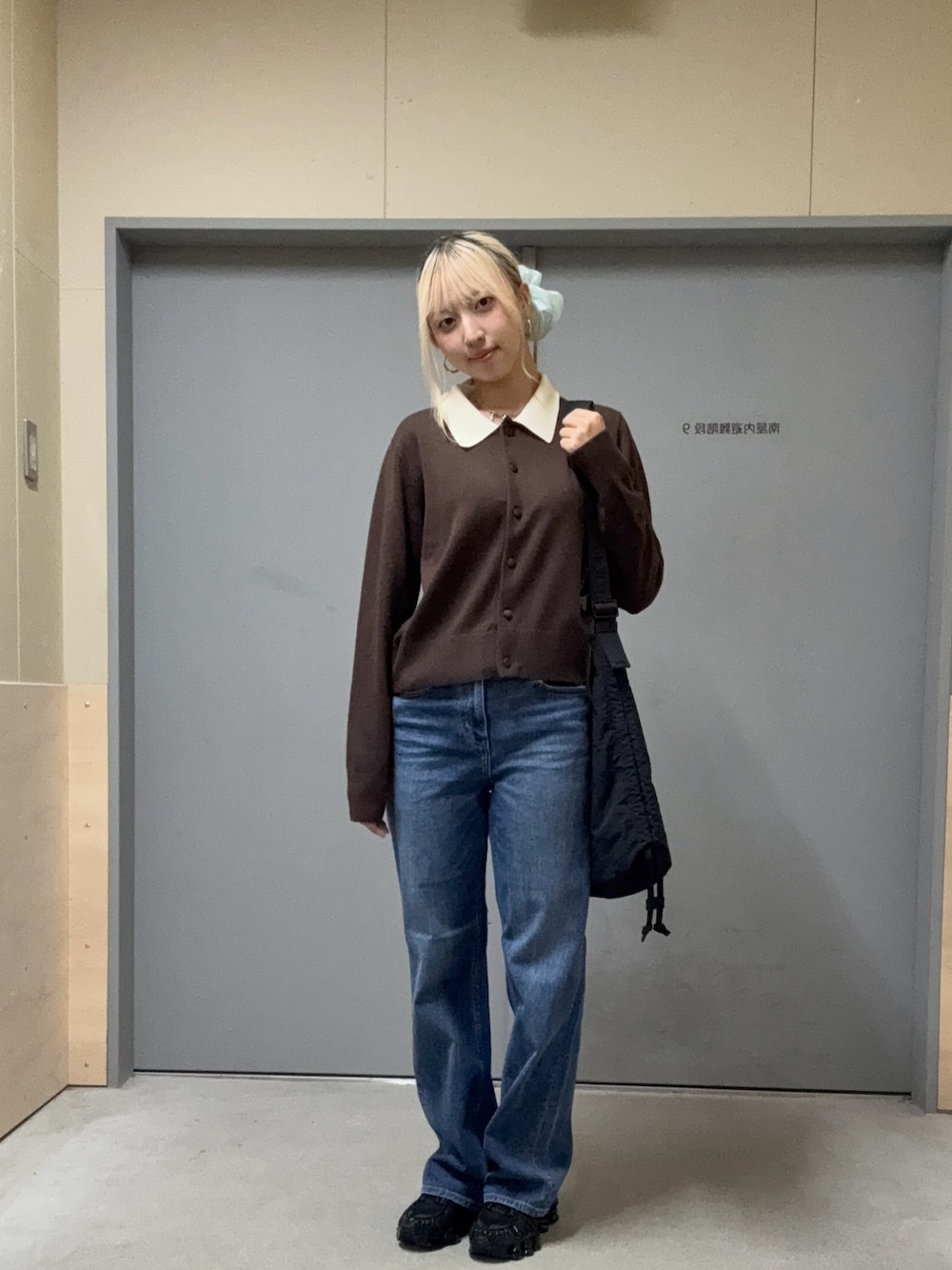 ブラウン系のニット/セーター、ブルー系のデニムパンツ、ブラック系のその他雑貨を着用したレディースの秋コーディネートの1枚目の写真
