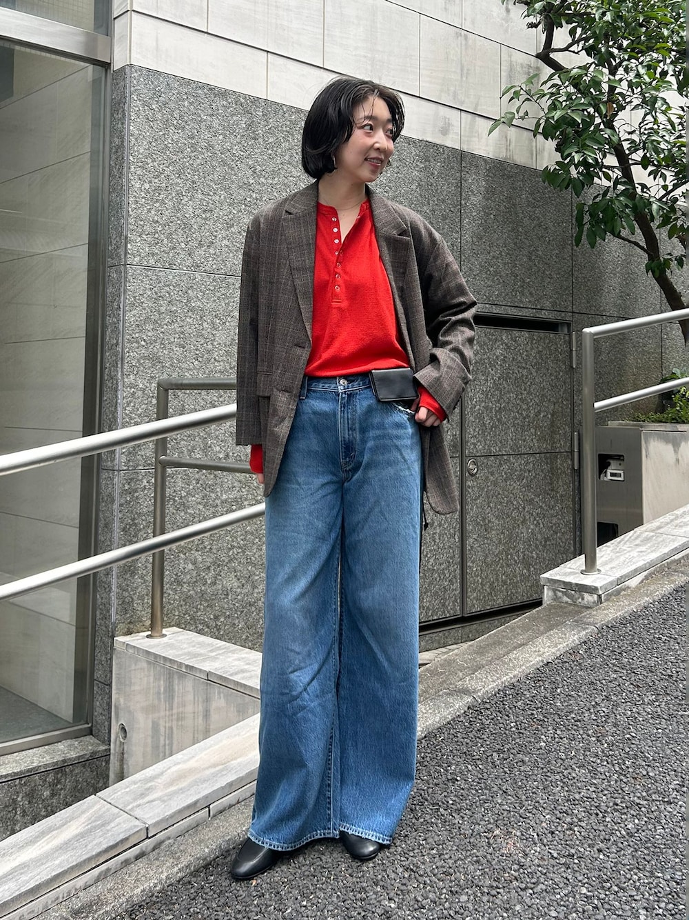 ブラウン系のテーラードジャケット、ブルー系のデニムパンツ、レッド系のTシャツ/カットソーを着用したレディースの夏コーディネートの1枚目の写真