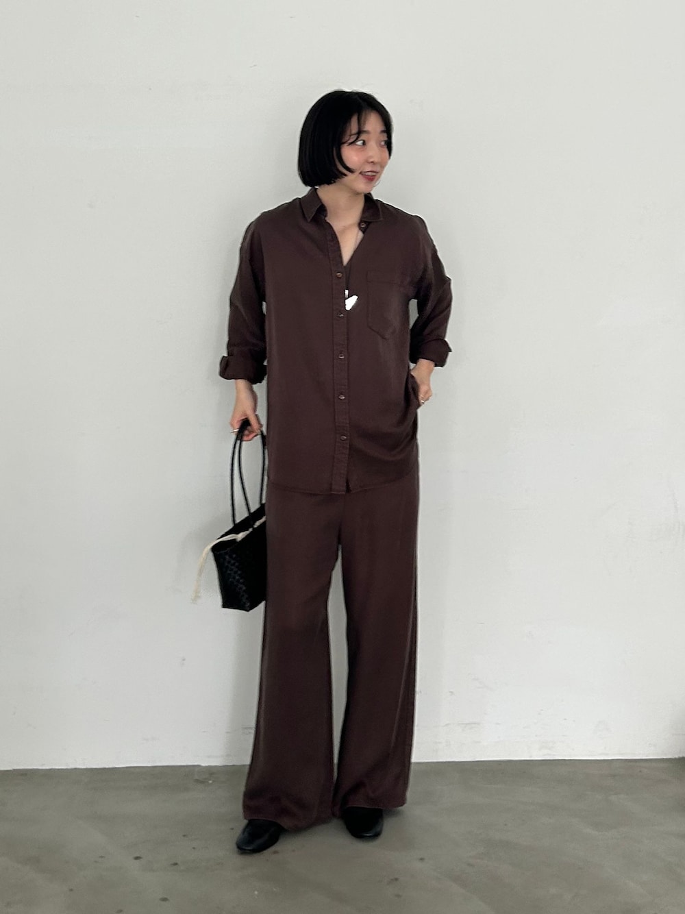 ブラウン系のその他パンツ、ブラウン系のシャツ/ブラウス、ブラック系のかごバッグを着用したレディースの夏コーディネートの1枚目の写真