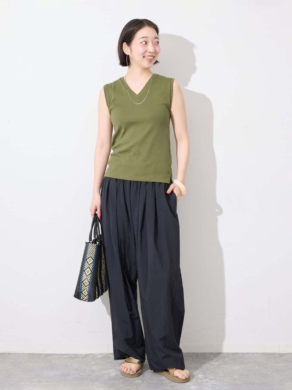 ブラック系のその他パンツ、グリーン系のTシャツ/カットソー、ブルー系のトートバッグを着用したレディースの夏コーディネートの1枚目の写真