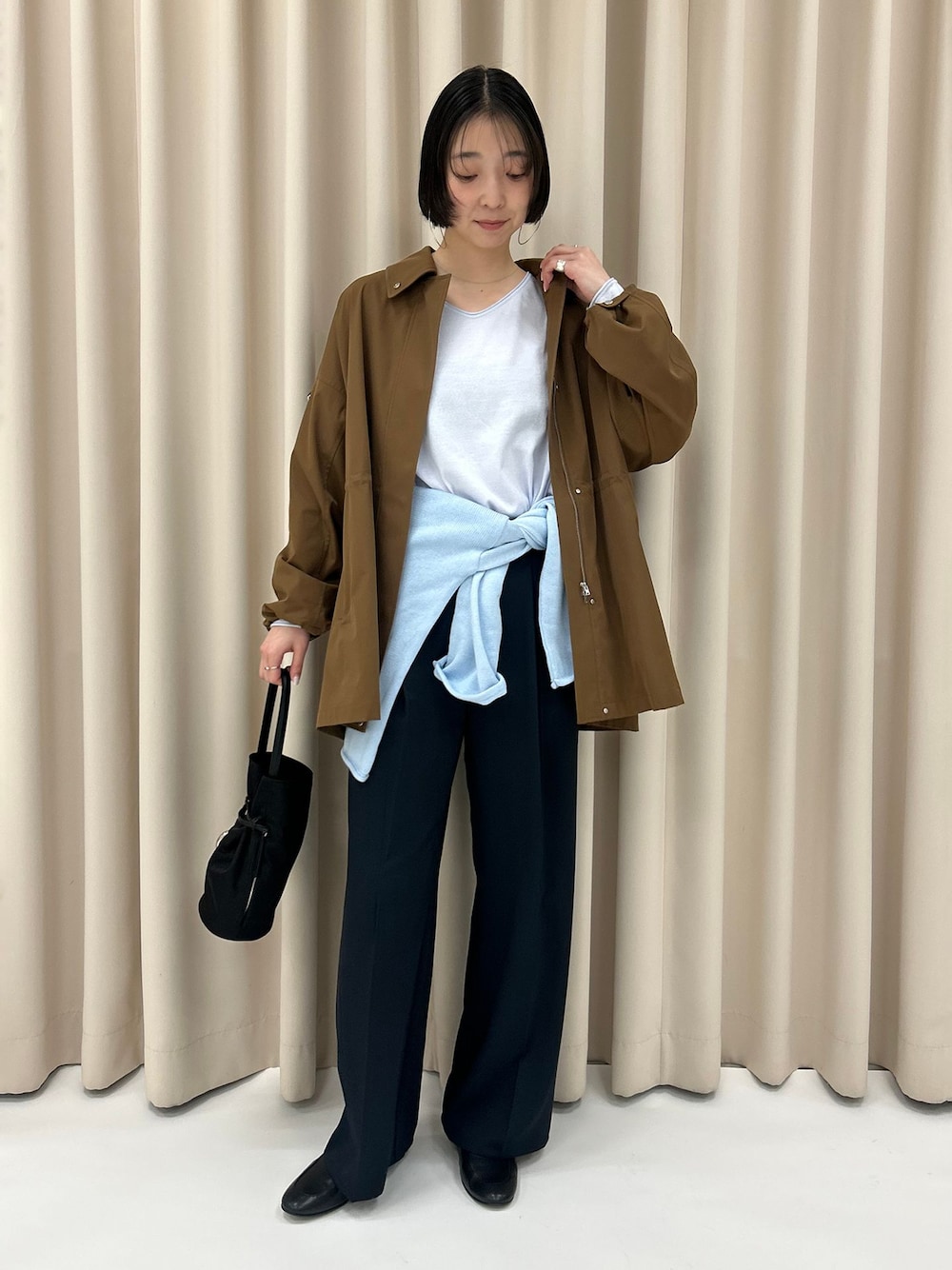 ブラック系のローファー、イエロー系のその他アウター、ブルー系のニット/セーターを着用したレディースの冬コーディネートの1枚目の写真