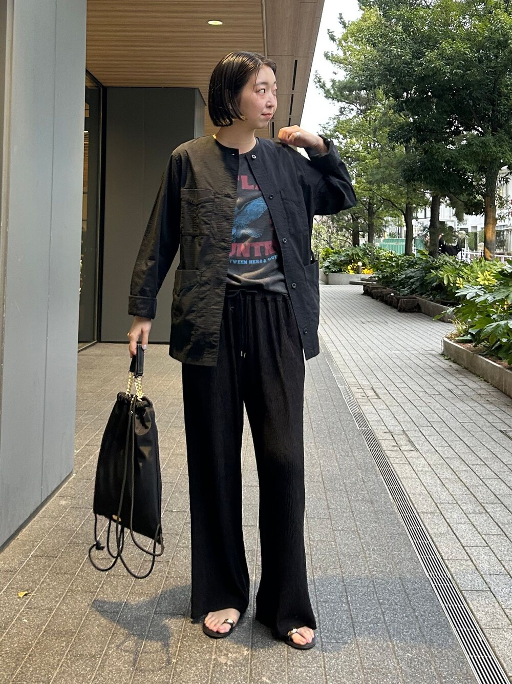 ブラック系のその他アウター、ブラック系のその他パンツ、ブラック系のバックパック/リュックを着用したレディースの春コーディネートの1枚目の写真