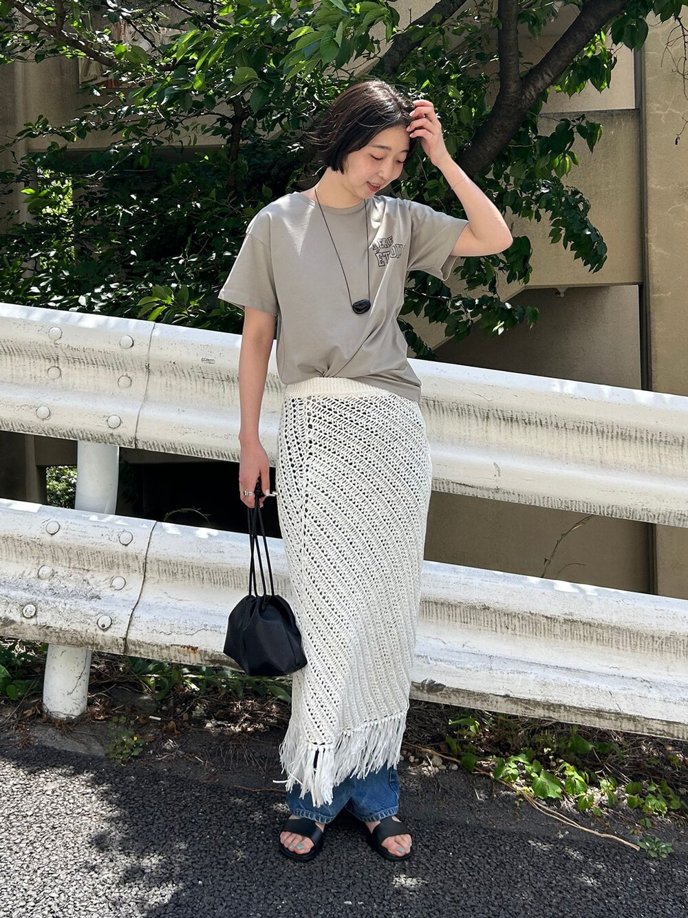 ブルー系のデニムパンツ、ホワイト系のスカート、グリーン系のTシャツ/カットソーを着用したレディースの春コーディネートの1枚目の写真