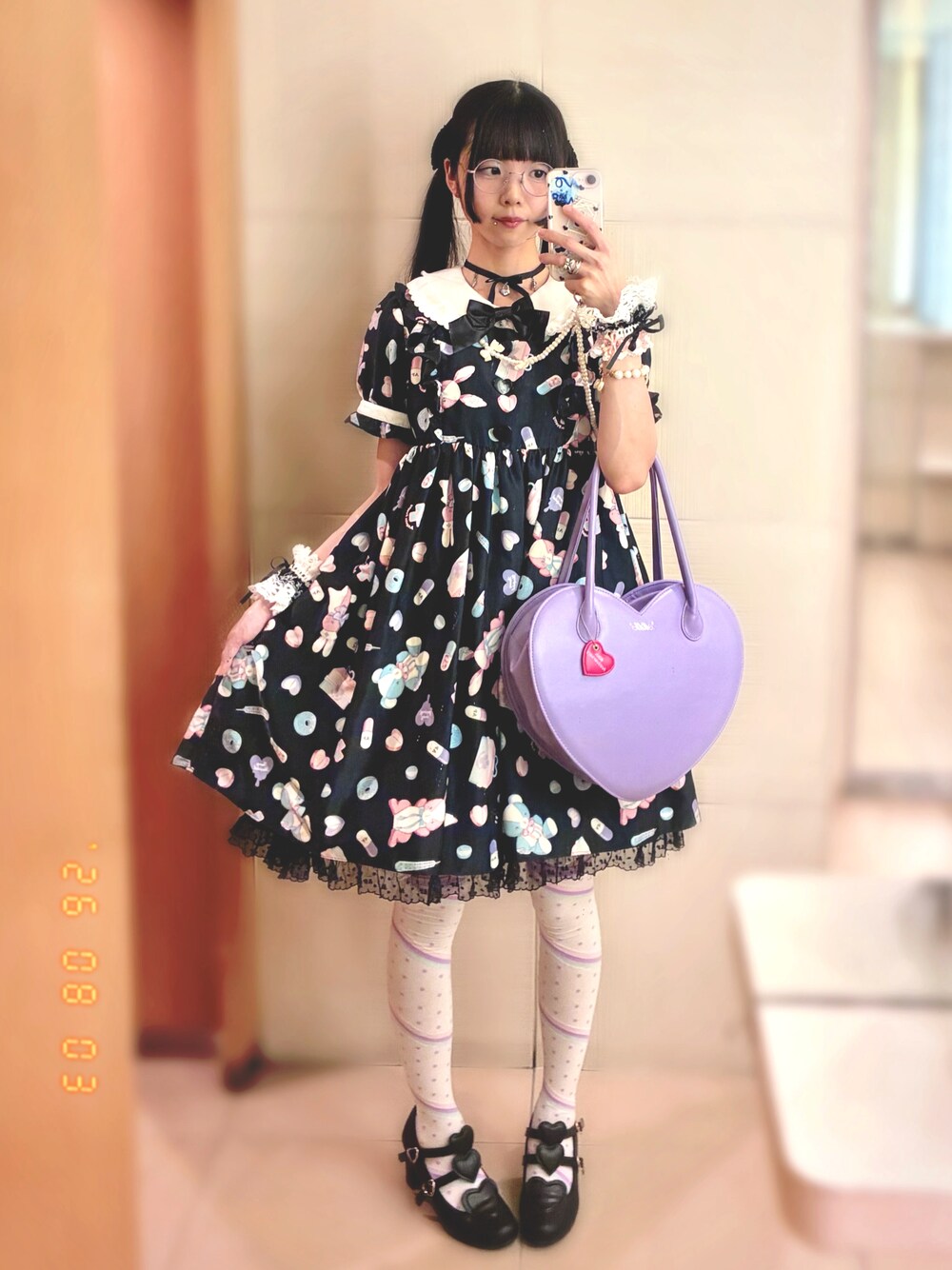 パープル系のショルダーバッグ、ブラック系のワンピース、ブラック系のパンプスを着用したレディースの夏コーディネートの1枚目の写真