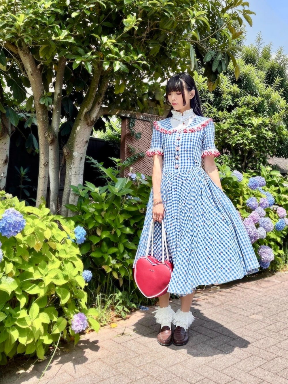 ブラウン系のローファー、ブルー系のワンピース、その他のショルダーバッグを着用したレディースの春コーディネートの1枚目の写真
