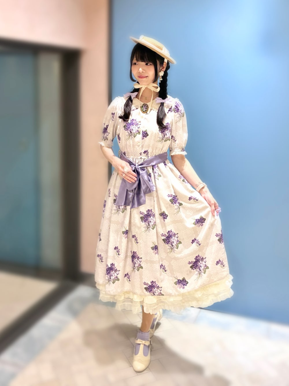 ホワイト系のワンピース、ホワイト系のパンプス、ベージュ系のジャンパースカートを着用したレディースの夏コーディネートの1枚目の写真