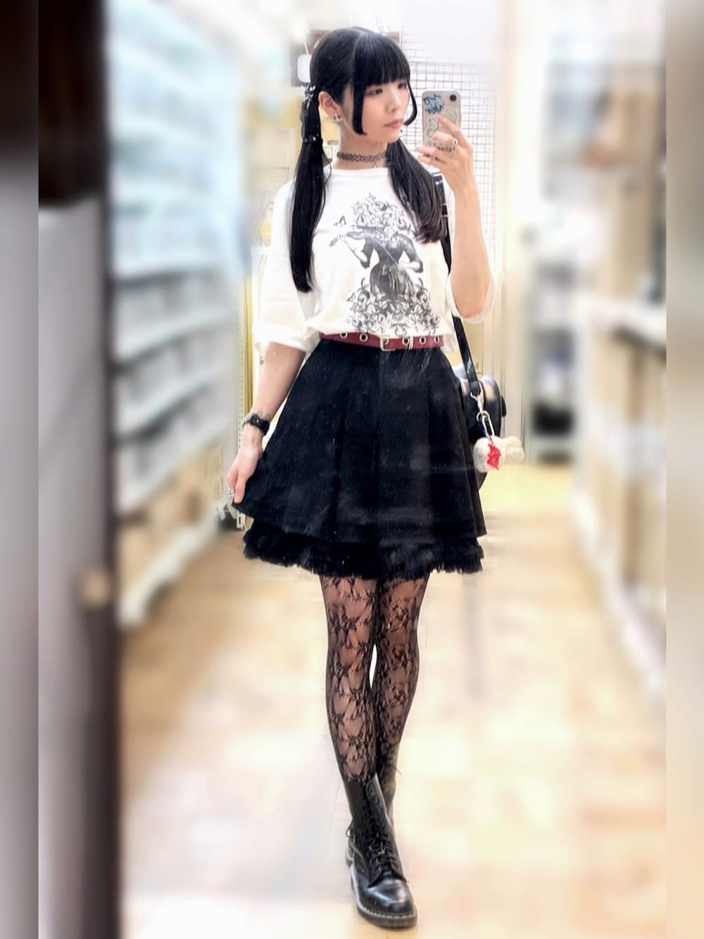 ブラック系のスカート、ホワイト系のTシャツ/カットソー、ブラック系のブーツを着用したレディースの夏コーディネートの1枚目の写真