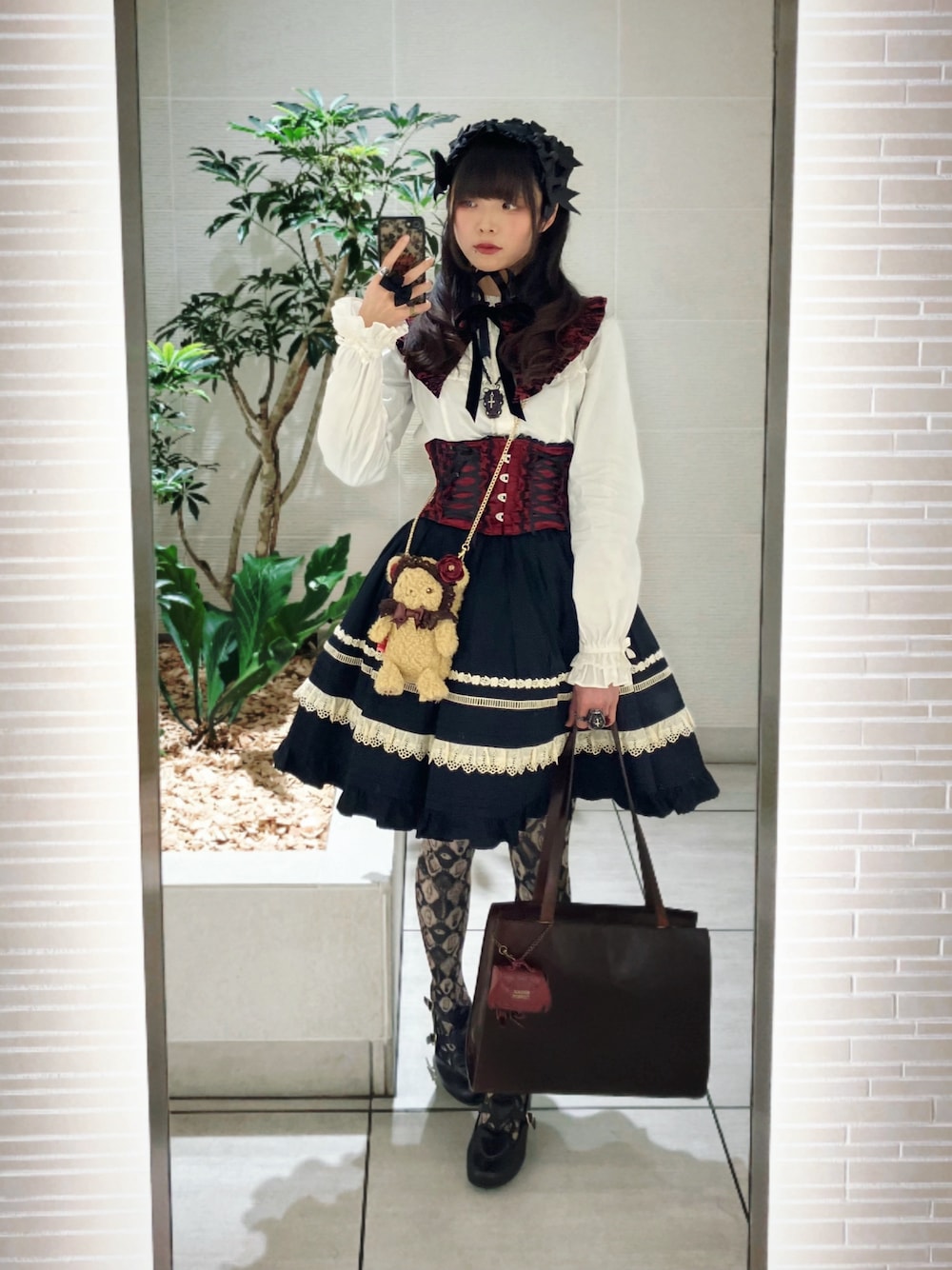 ホワイト系のシャツ/ブラウス、ブラック系のスカート、ブラウン系のバッグを着用したレディースの春コーディネートの1枚目の写真