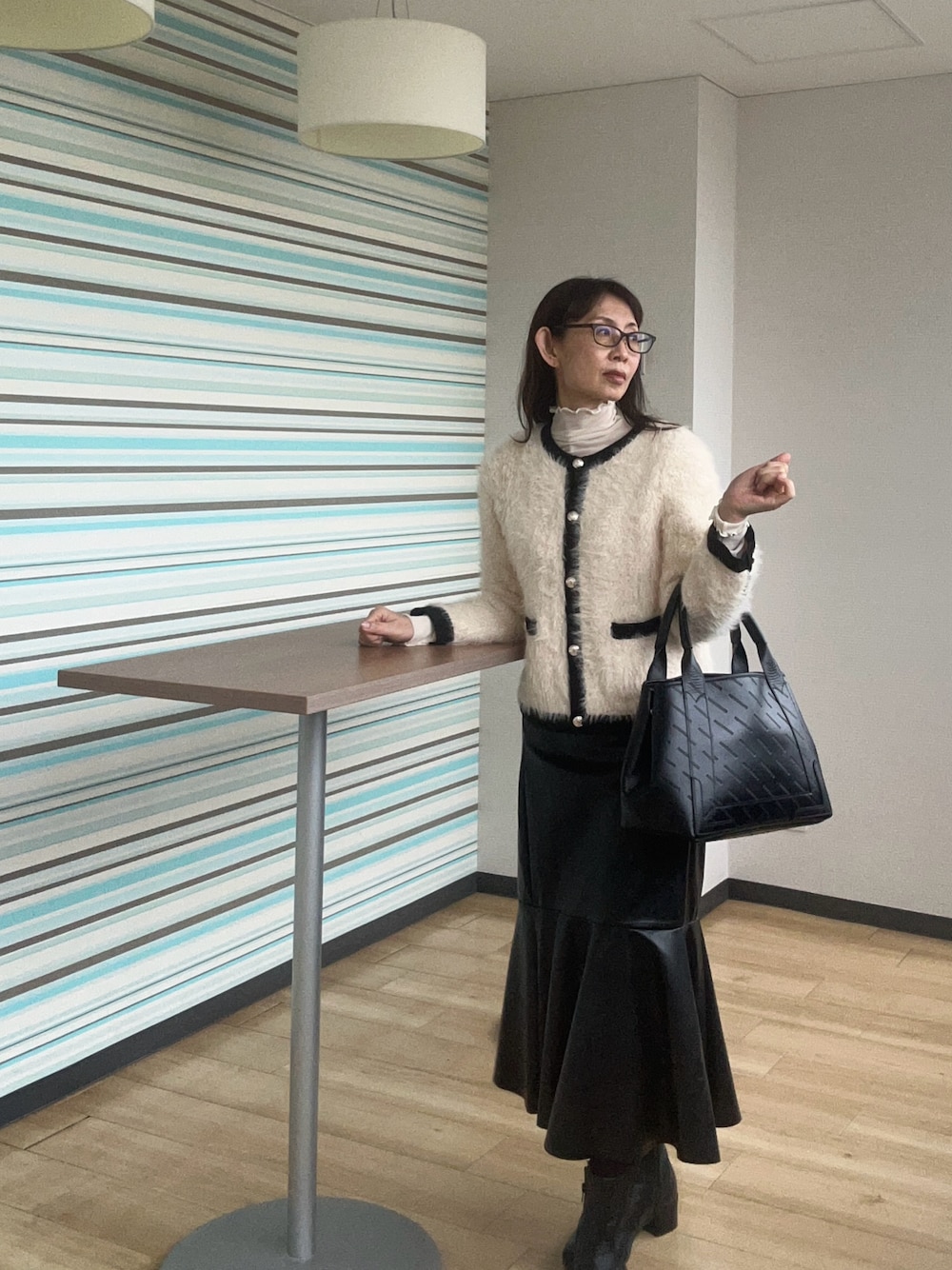 ホワイト系のカーディガン/ボレロ、ブラック系のトートバッグを着用したレディースの春コーディネートの1枚目の写真