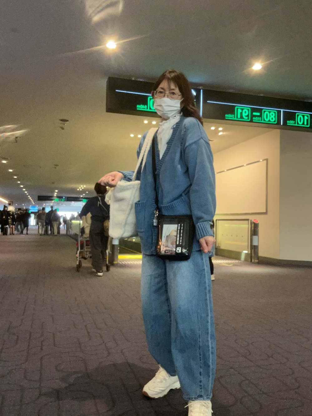 ブルー系のニット/セーターを着用したレディースの冬コーディネートの1枚目の写真