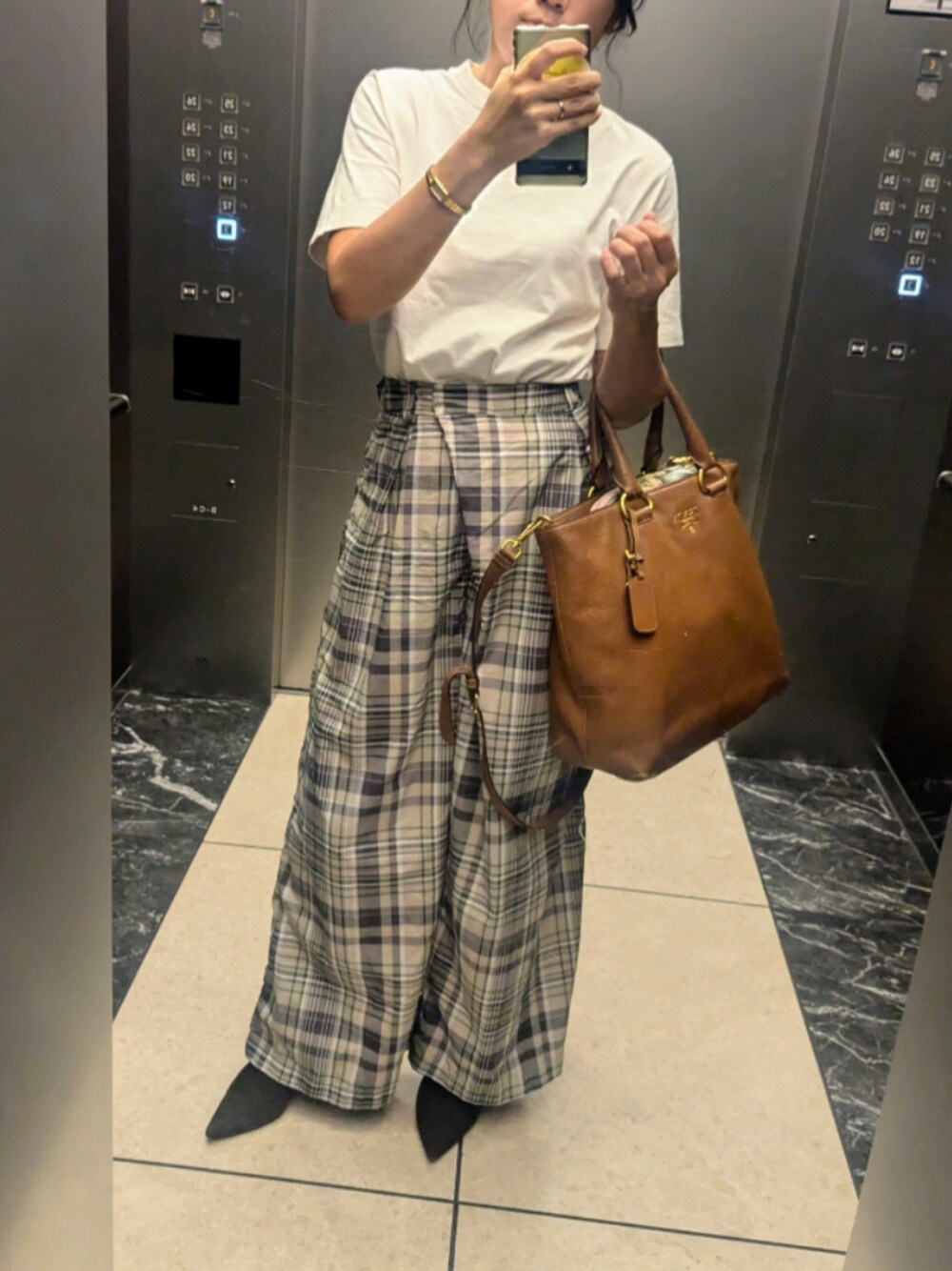 ベージュ系のその他パンツ、ブラウン系のブーツ、ホワイト系のTシャツ/カットソーを着用したレディースの秋コーディネートの1枚目の写真