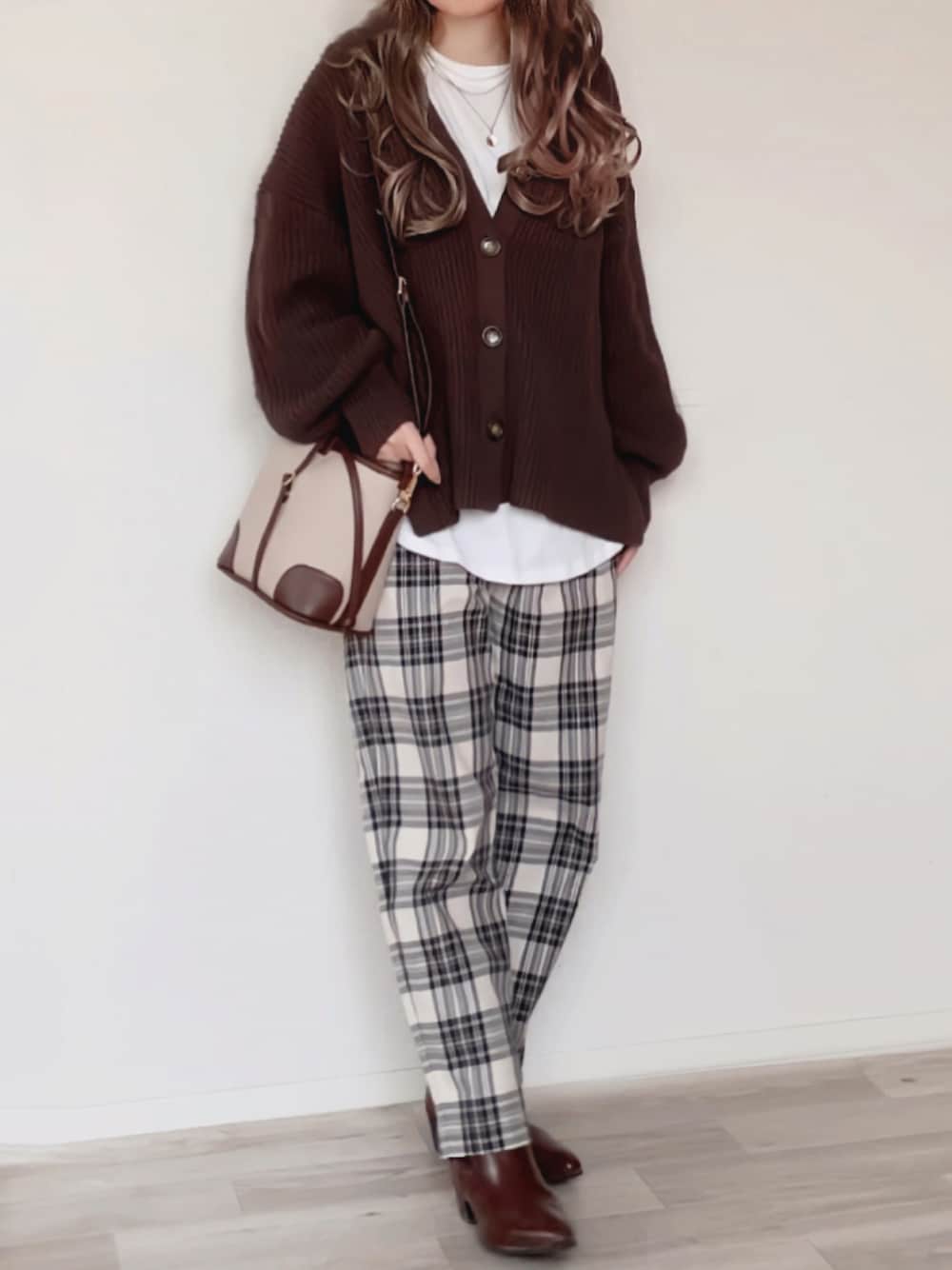 ブラウン系のカーディガン/ボレロ、ホワイト系のTシャツ/カットソー、ブラック系のパンツを着用したレディースの秋コーディネートの1枚目の写真