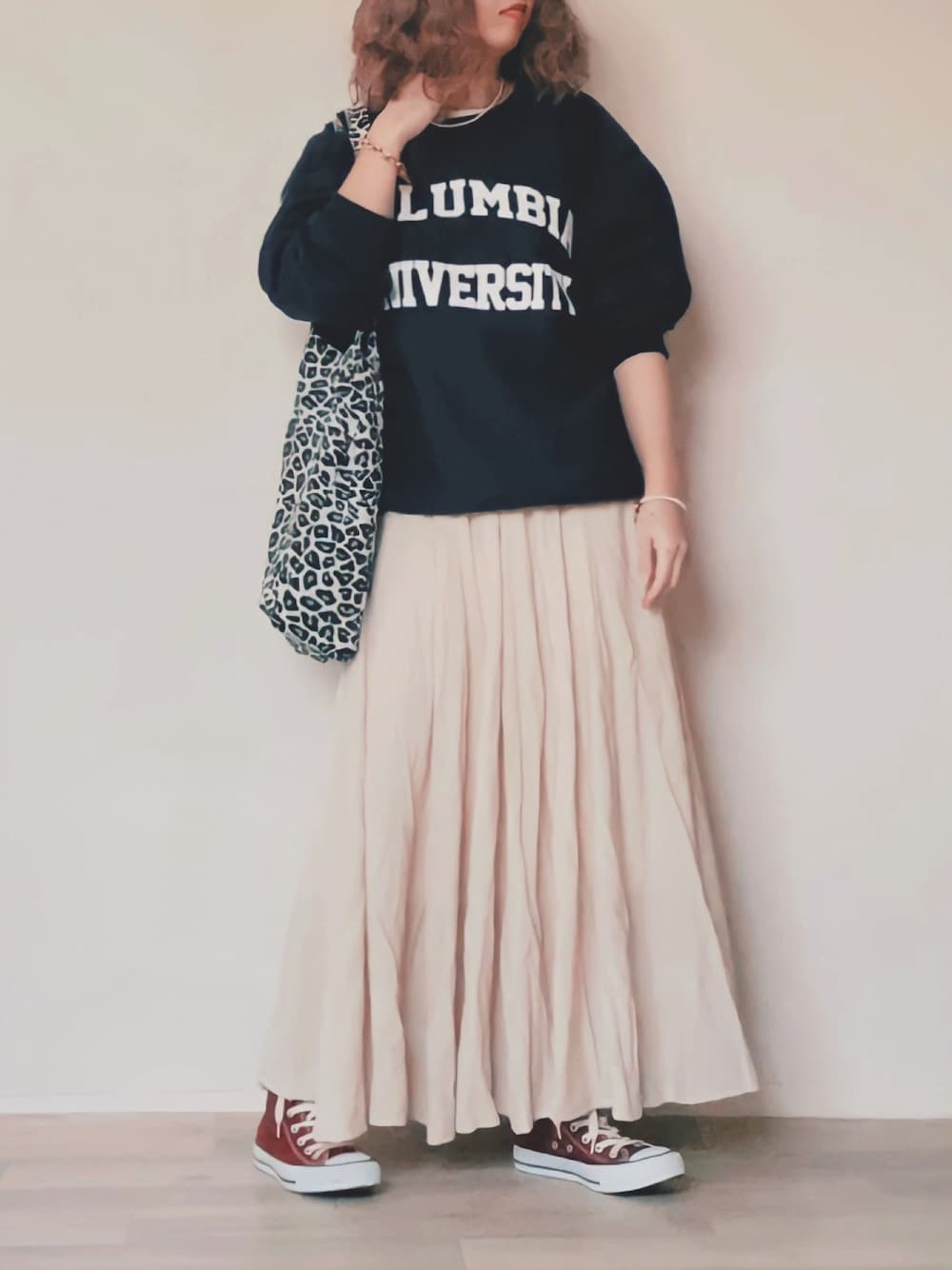 ブルー系のスウェット、ホワイト系のスカート、レッド系のスニーカーを着用したレディースの秋コーディネートの1枚目の写真