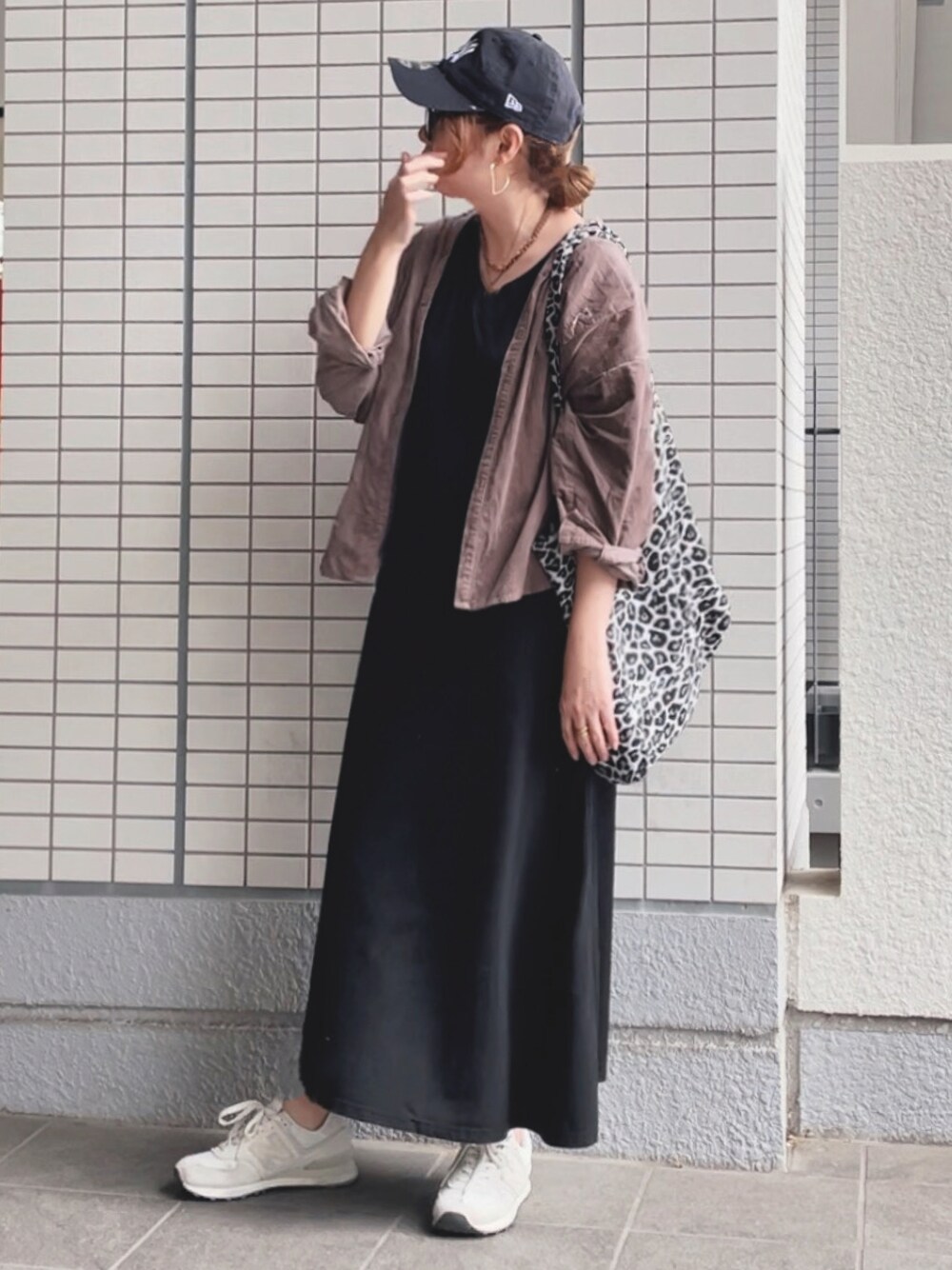 ブラック系のワンピース、ホワイト系のスニーカー、ブラック系のトートバッグを着用したレディースの秋コーディネートの1枚目の写真