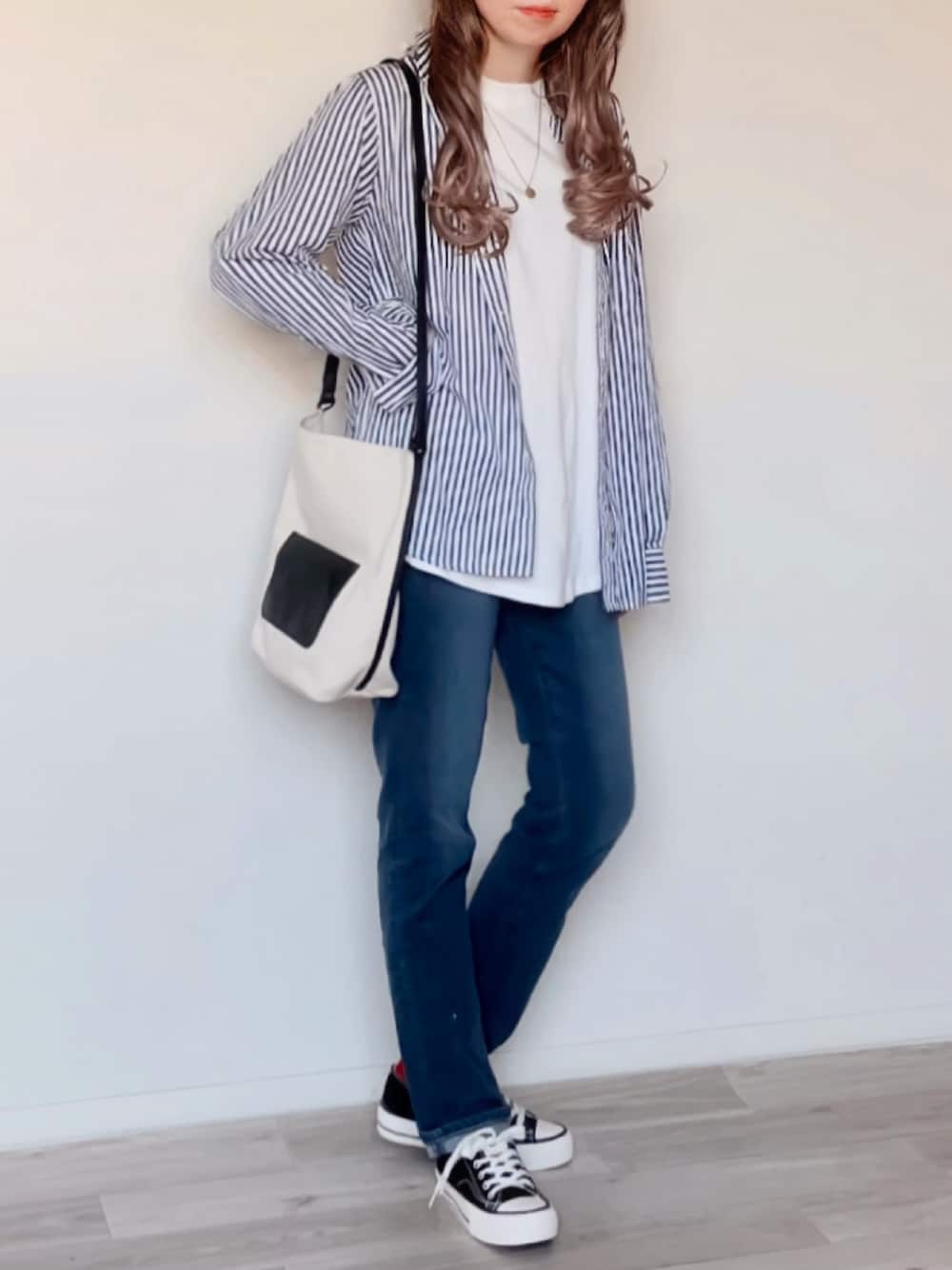 ブルー系のシャツ/ブラウス、ホワイト系のTシャツ/カットソー、パープル系のデニムパンツを着用したレディースの秋コーディネートの1枚目の写真