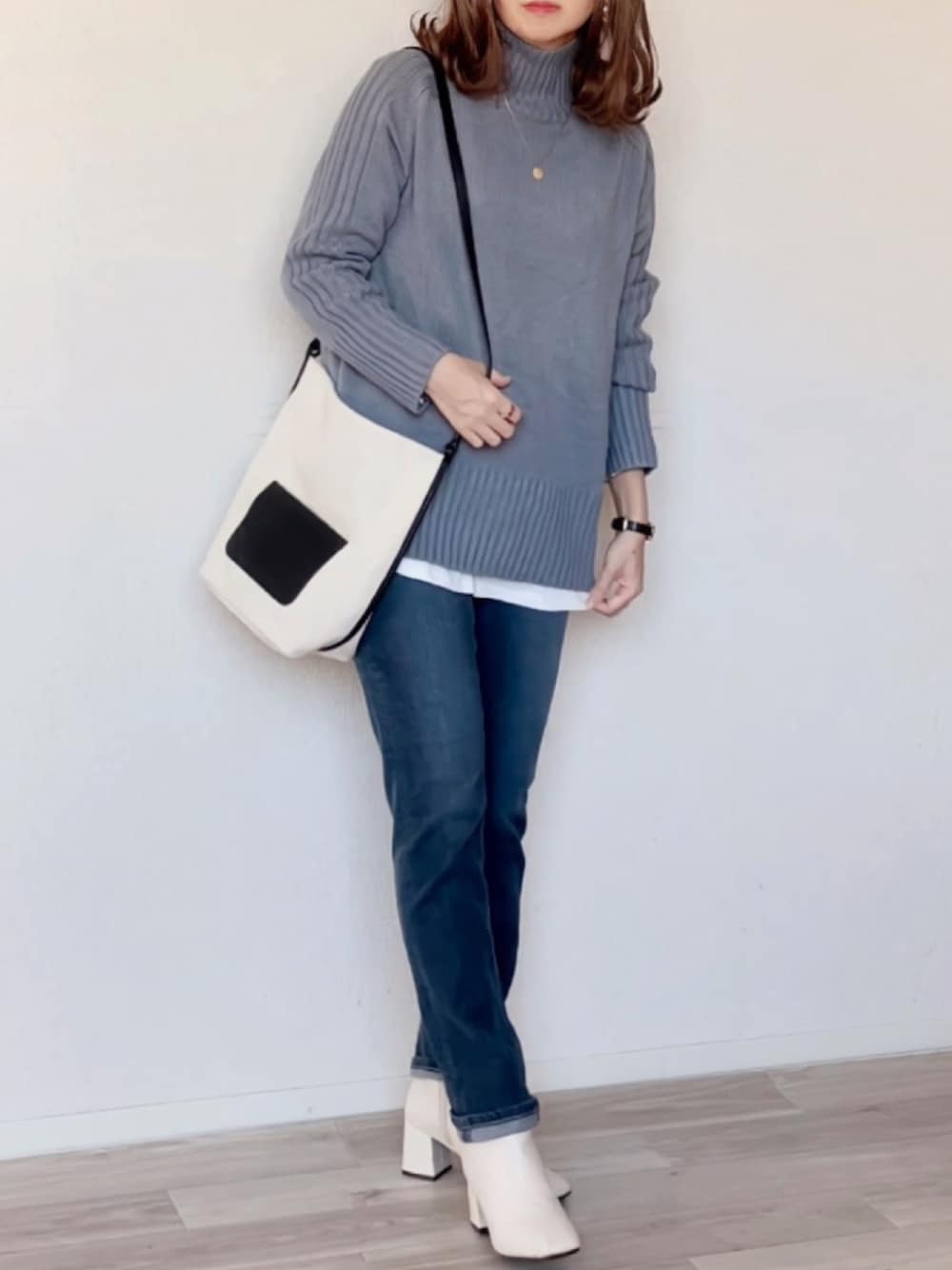 ブルー系のニット/セーター、パープル系のデニムパンツ、ホワイト系のブーツを着用したレディースの秋コーディネートの1枚目の写真