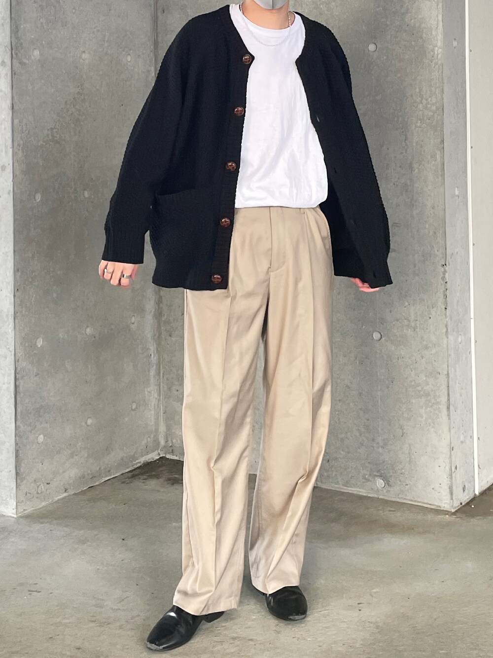 ホワイト系のTシャツ/カットソー、ブラック系のカーディガン/ボレロ、ベージュ系のスラックスを着用したメンズの冬コーディネートの1枚目の写真