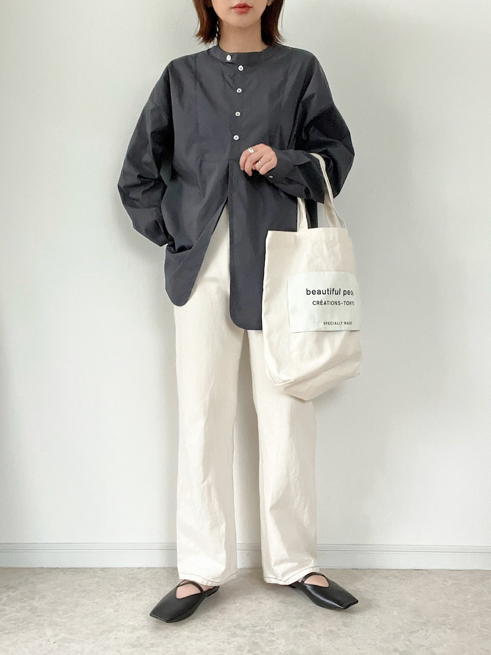 ブラック系のシャツ/ブラウス、ホワイト系のトートバッグ、ブラック系のパンプスを着用したレディースの秋コーディネートの1枚目の写真