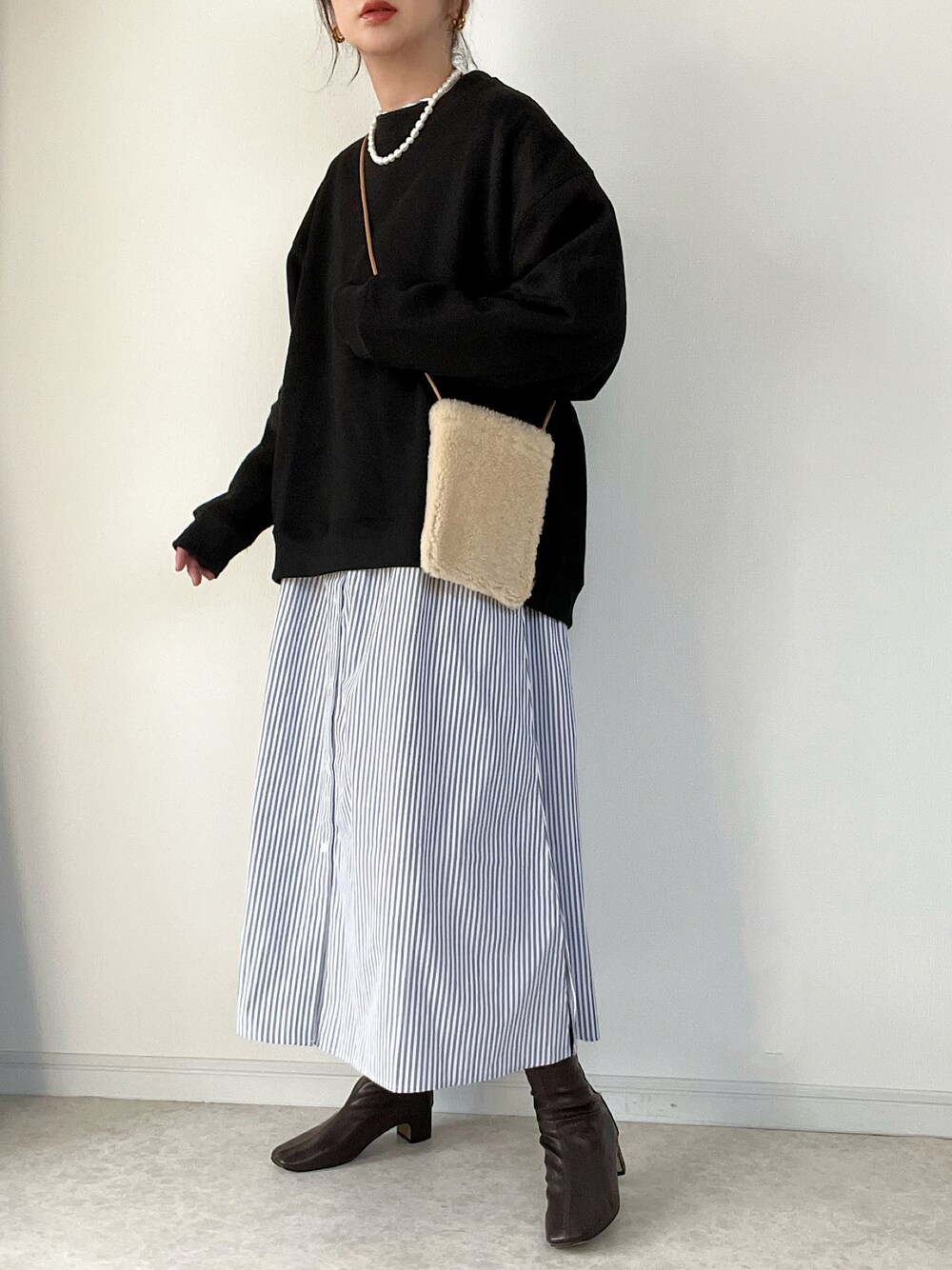 ブラック系のスウェット、グレー系のシャツワンピース、ベージュ系のショルダーバッグを着用したレディースの秋コーディネートの1枚目の写真