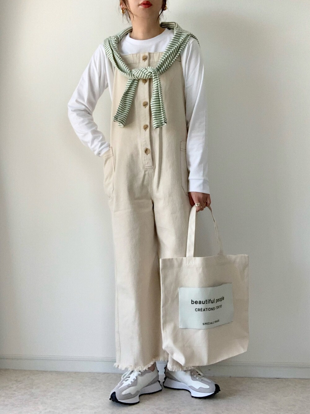 ホワイト系のTシャツ/カットソー、ブルー系のカーディガン/ボレロ、ベージュ系のサロペット/オーバーオールを着用したレディースの春コーディネートの1枚目の写真