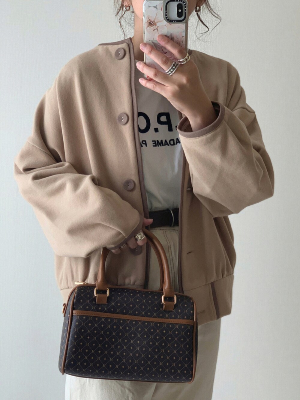 ホワイト系のデニムパンツ、ブラウン系のボストンバッグ、ベージュ系のカーディガン/ボレロを着用したレディースの夏コーディネートの1枚目の写真