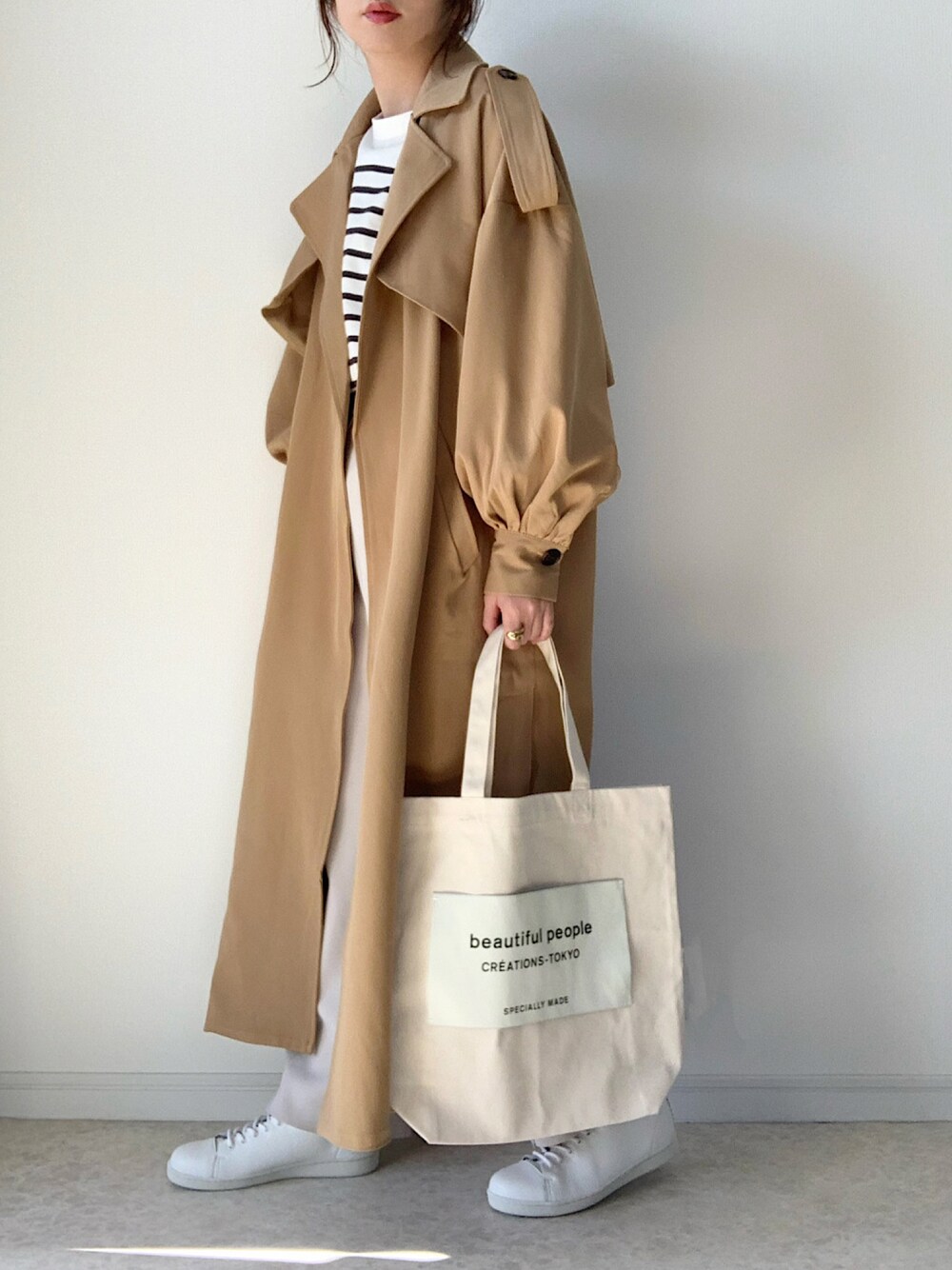 ベージュ系のトレンチコート、ホワイト系のTシャツ/カットソー、ベージュ系のその他パンツを着用したレディースの冬コーディネートの1枚目の写真