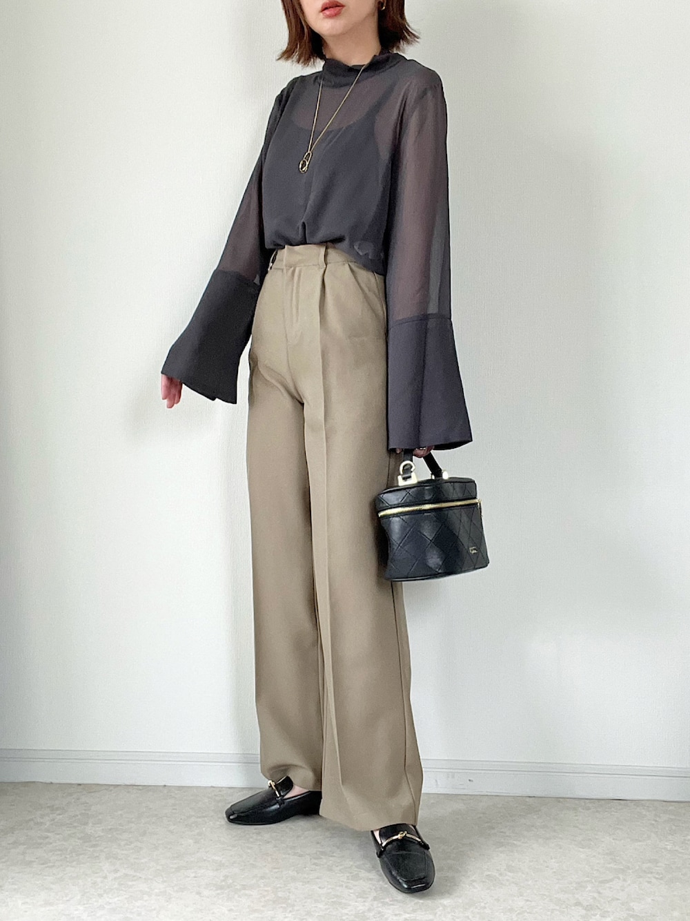 グレー系のシャツ/ブラウス、ブラウン系のスラックス、ブラック系のショルダーバッグを着用したレディースの夏コーディネートの1枚目の写真