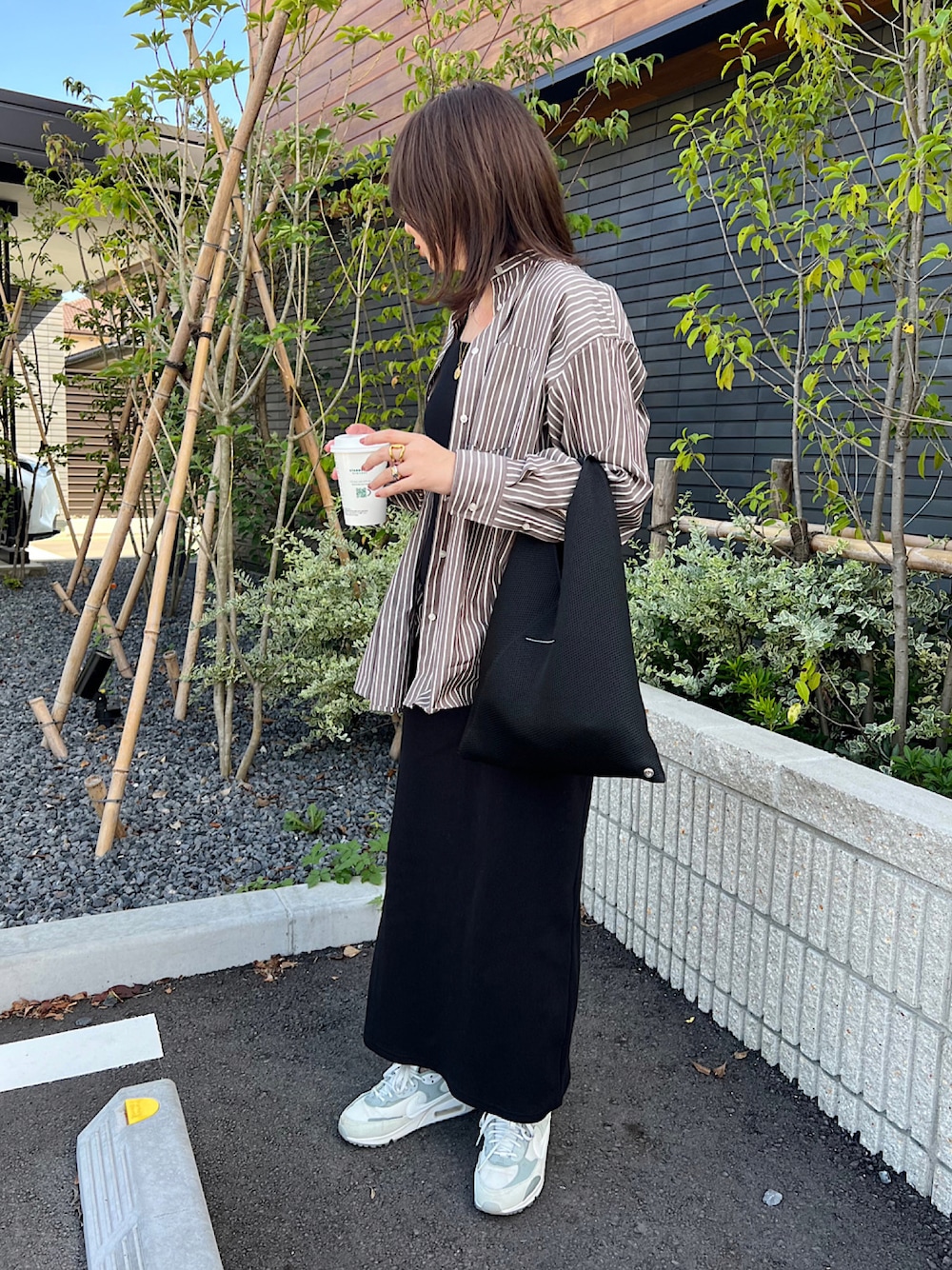 ブラウン系のシャツ/ブラウス、ブラック系のワンピース、ブラック系のトートバッグを着用したレディースの秋コーディネートの1枚目の写真