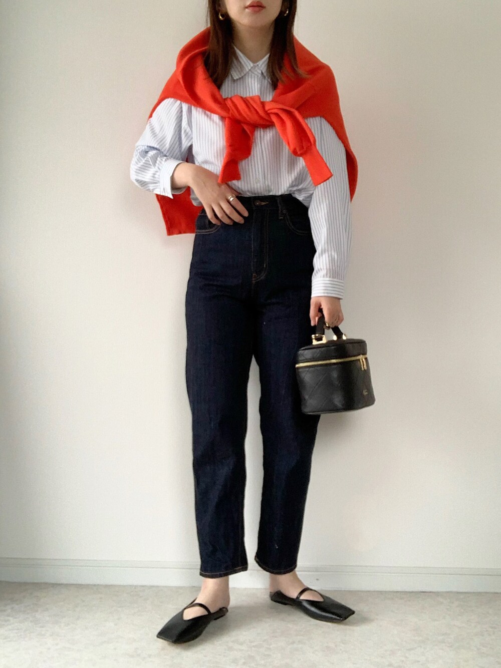 ブルー系のシャツ/ブラウス、オレンジ系のカーディガン/ボレロ、ブルー系のデニムパンツを着用したレディースの春コーディネートの1枚目の写真
