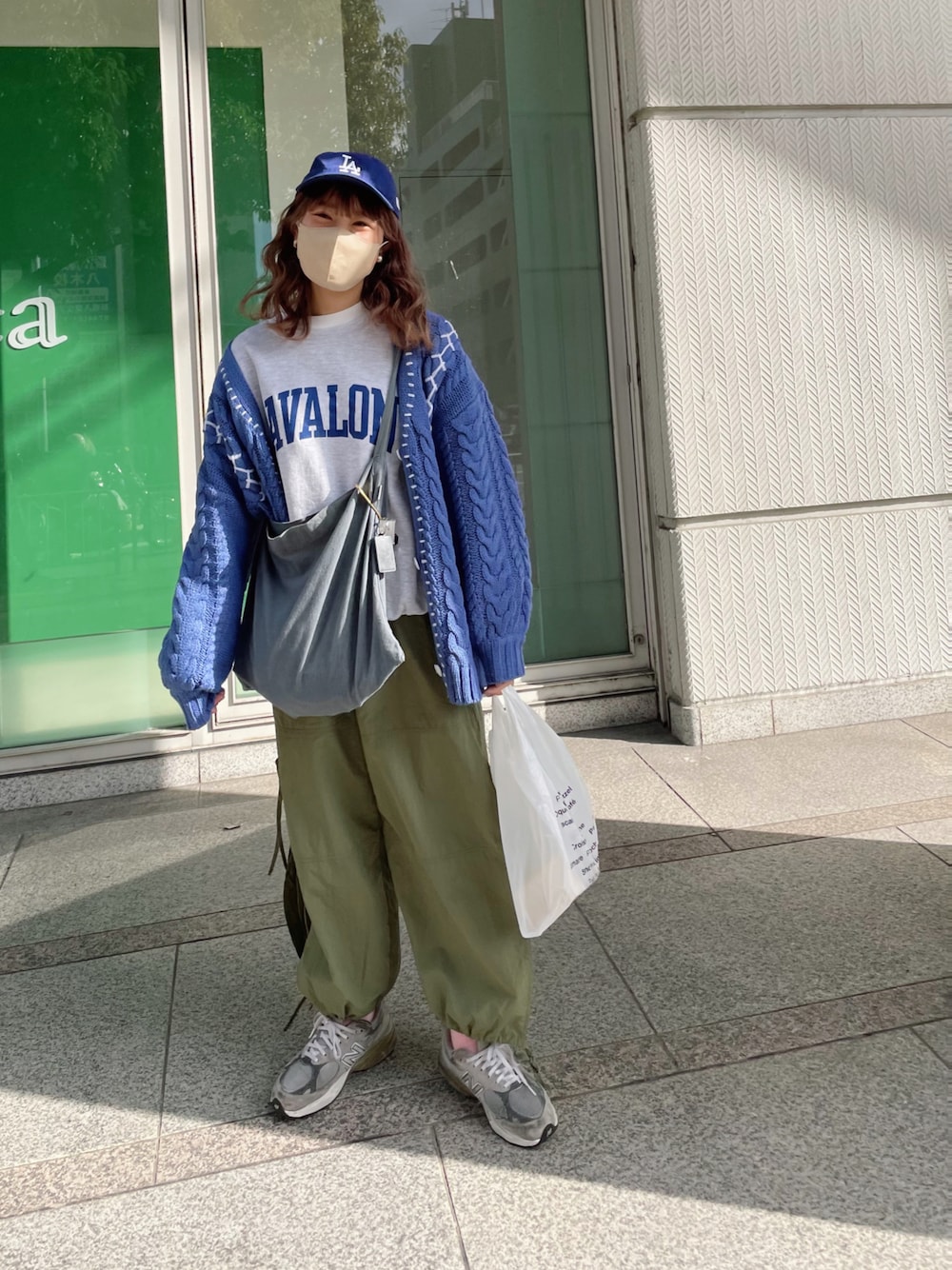 グレー系のスウェット、ブルー系のカーディガン/ボレロ、グリーン系のカーゴパンツを着用したレディースの秋コーディネートの1枚目の写真