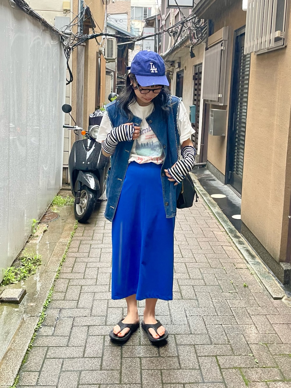 「夏のコスメと服、今日のコスメと服、夏コーデ、カジュアルコーデ、カラーコーデ、カラースカート、ブルーコーデ、キャップ、Tシャツ、デニムベスト、ダテメガネ、oofos、アームウォーマー、ゆったりコーデ、お洒落さんとつながりたい」｜「DISCOATのCamBridgeスーベニアビックTシャツ（Tシャツ/カットソー、ホワイト系）」を使った、ponさん（レディース・163cm）の夏コーディネートの1枚目の写真
