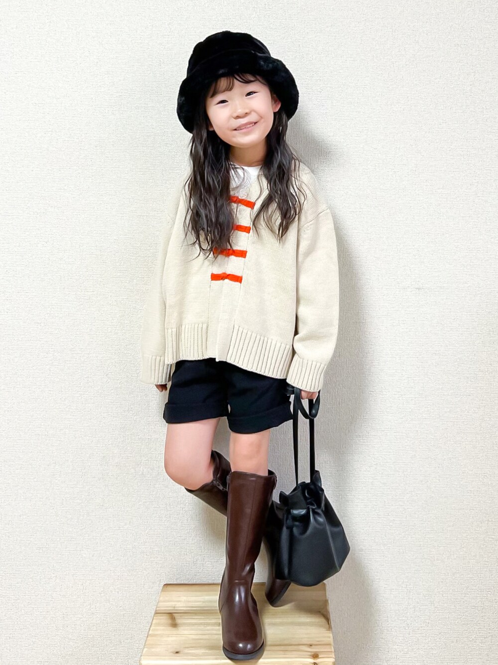 ホワイト系のニット/セーター、ホワイト系のTシャツ/カットソー、ブラック系のその他パンツを着用したキッズの秋コーディネートの1枚目の写真
