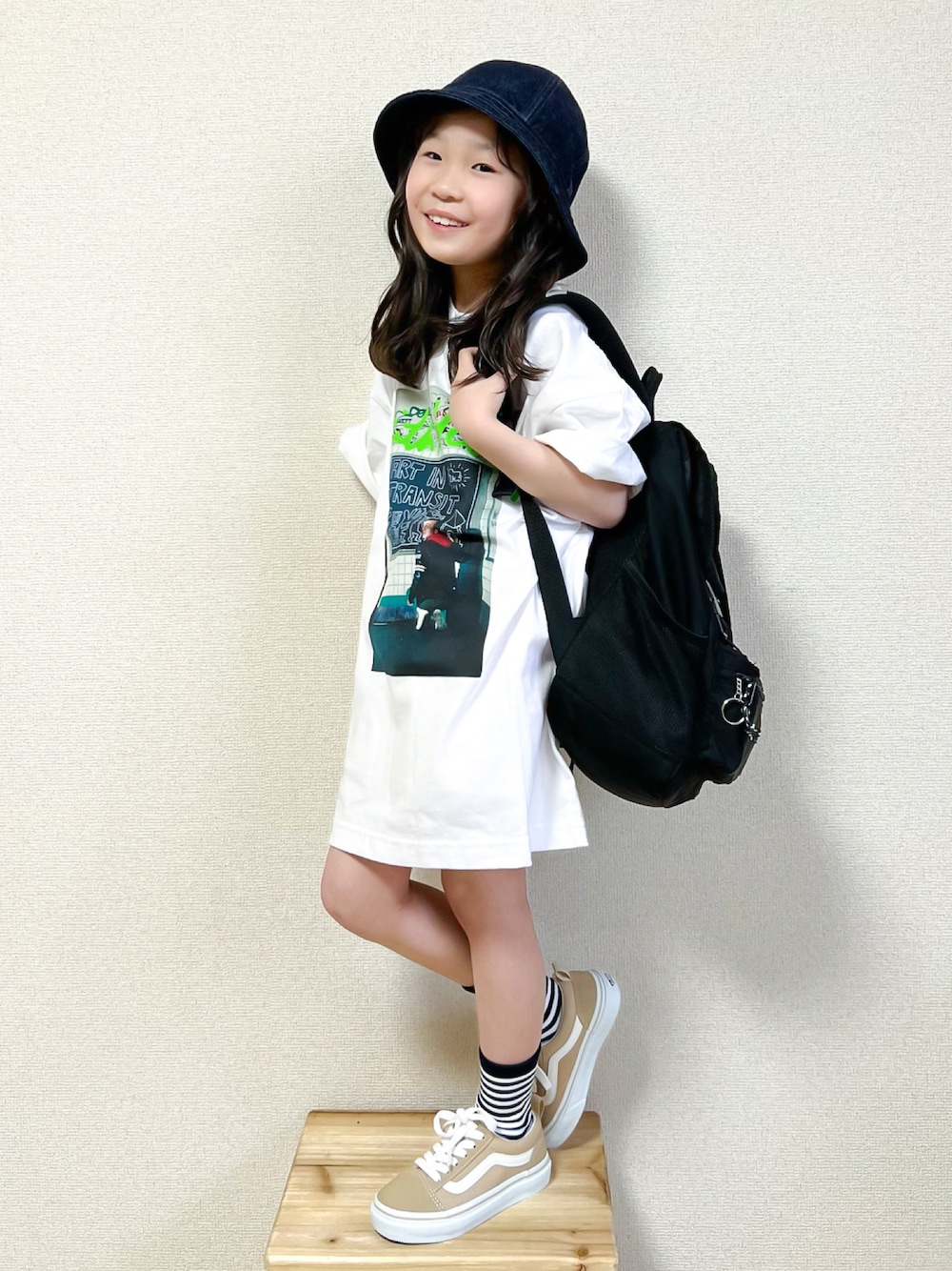 ホワイト系のTシャツ/カットソー、ベージュ系のスニーカー、ブラック系のバックパック/リュックを着用したキッズの春コーディネートの1枚目の写真