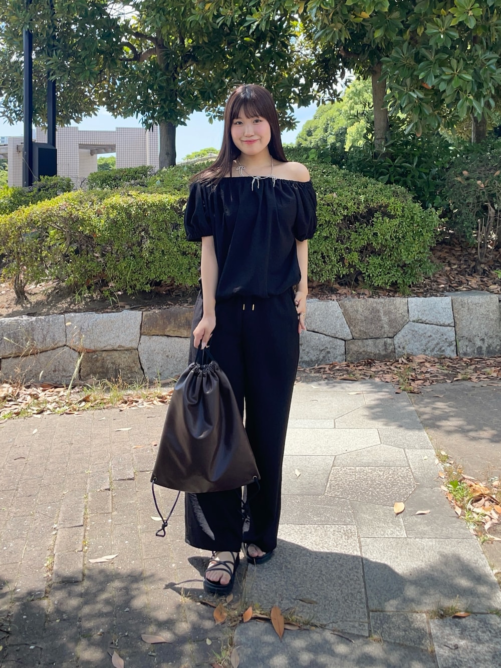 ブラック系のつなぎ/オールインワン、ブラウン系のバックパック/リュックを着用したレディースの夏コーディネートの1枚目の写真