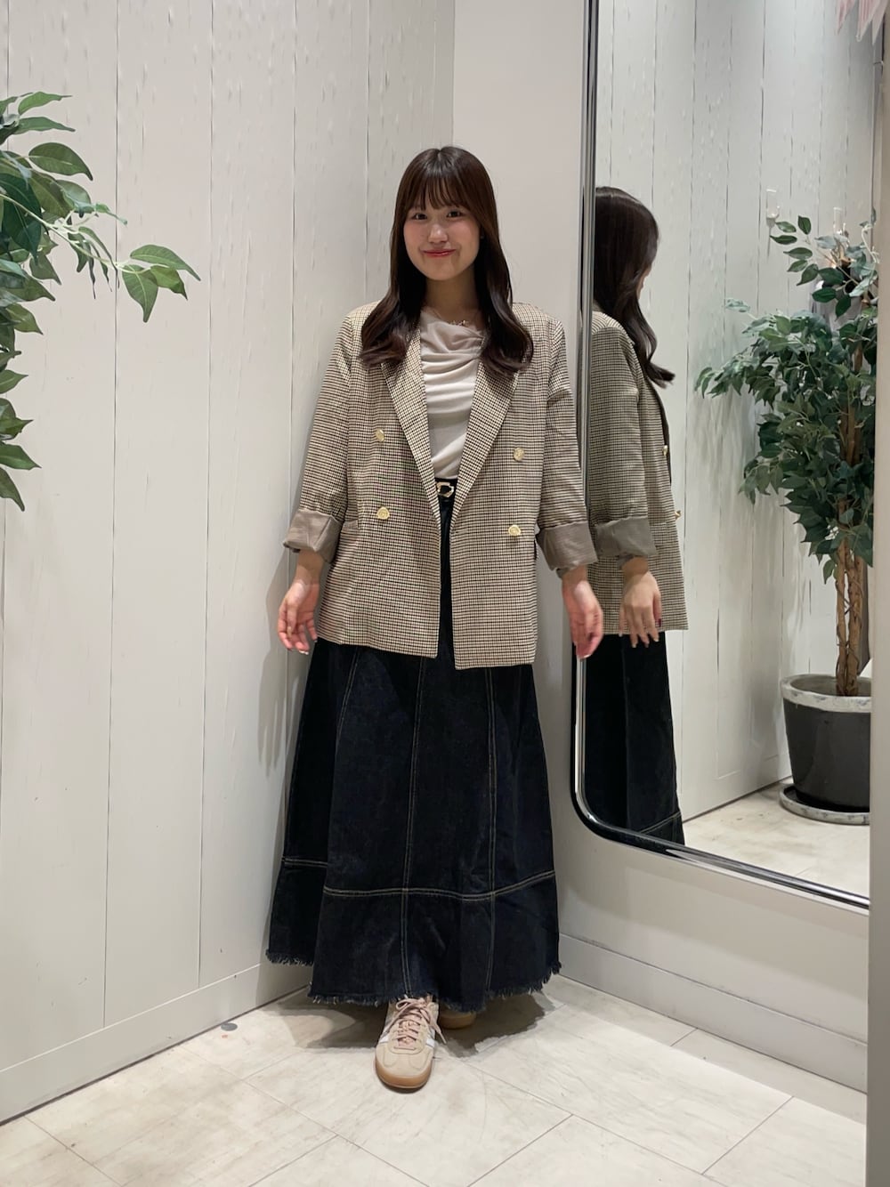 ベージュ系のTシャツ/カットソー、ベージュ系のテーラードジャケット、ブラック系のスカートを着用したレディースの秋コーディネートの1枚目の写真