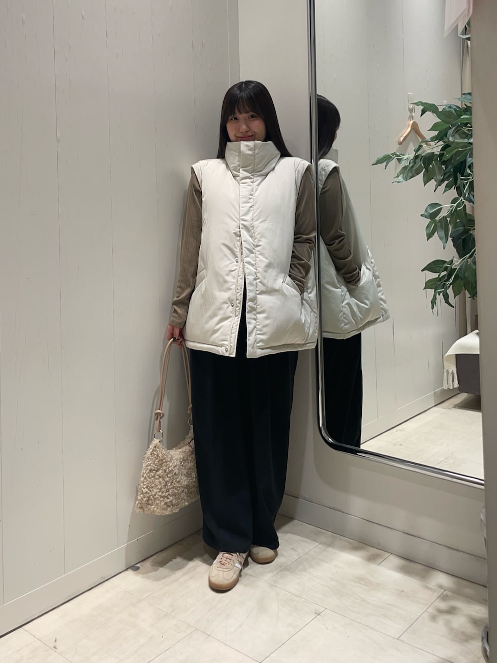 ホワイト系のブルゾン、ベージュ系のTシャツ/カットソー、ブラック系のスラックスを着用したレディースの冬コーディネートの1枚目の写真