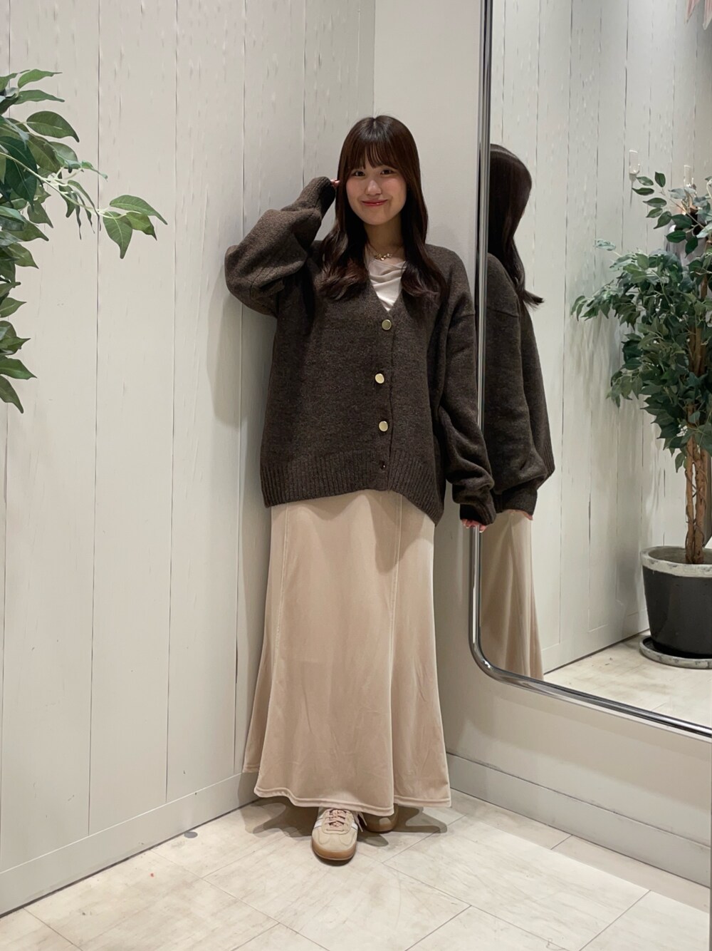 ホワイト系のスカート、ベージュ系のTシャツ/カットソー、ブラウン系のカーディガン/ボレロを着用したレディースの秋コーディネートの1枚目の写真