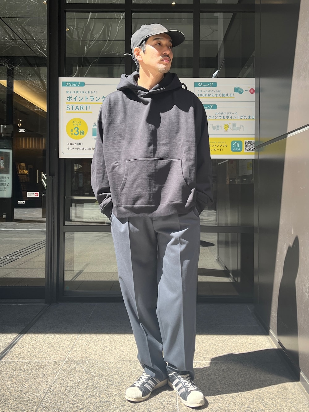 「春のおしゃ見えテクニック、スラックス、ストリート、メンズコーデ、シンプルスタイル、ファッションを楽しもう、大人カジュアル、ビッグシルエット、シンプルコーデ、パーカー、着回しコーデ」｜「markawareの【MARKAWARE/マーカウェア】別注 ORGANIC COTTON HUGE PARKA SHORT/別注 オーガニックコットンヒュージスウェットパーカーショート（パーカー、ブラック系）」を使った、THE TOKYO STAFFさん（メンズ・172cm）の春コーディネートの1枚目の写真