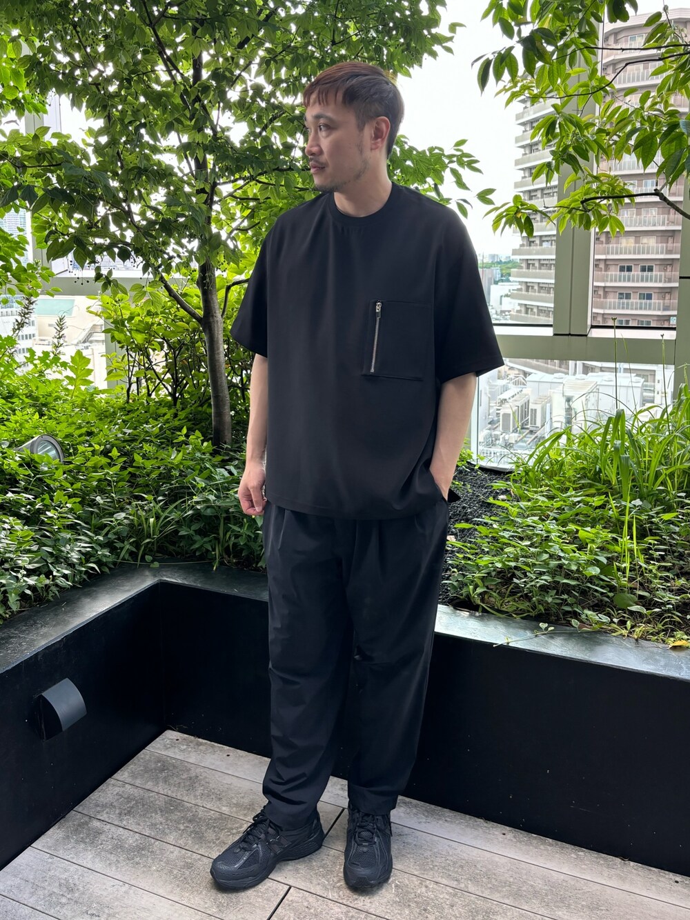 ブラック系のTシャツ/カットソー、ブラック系のスラックスを着用したメンズの夏コーディネートの1枚目の写真