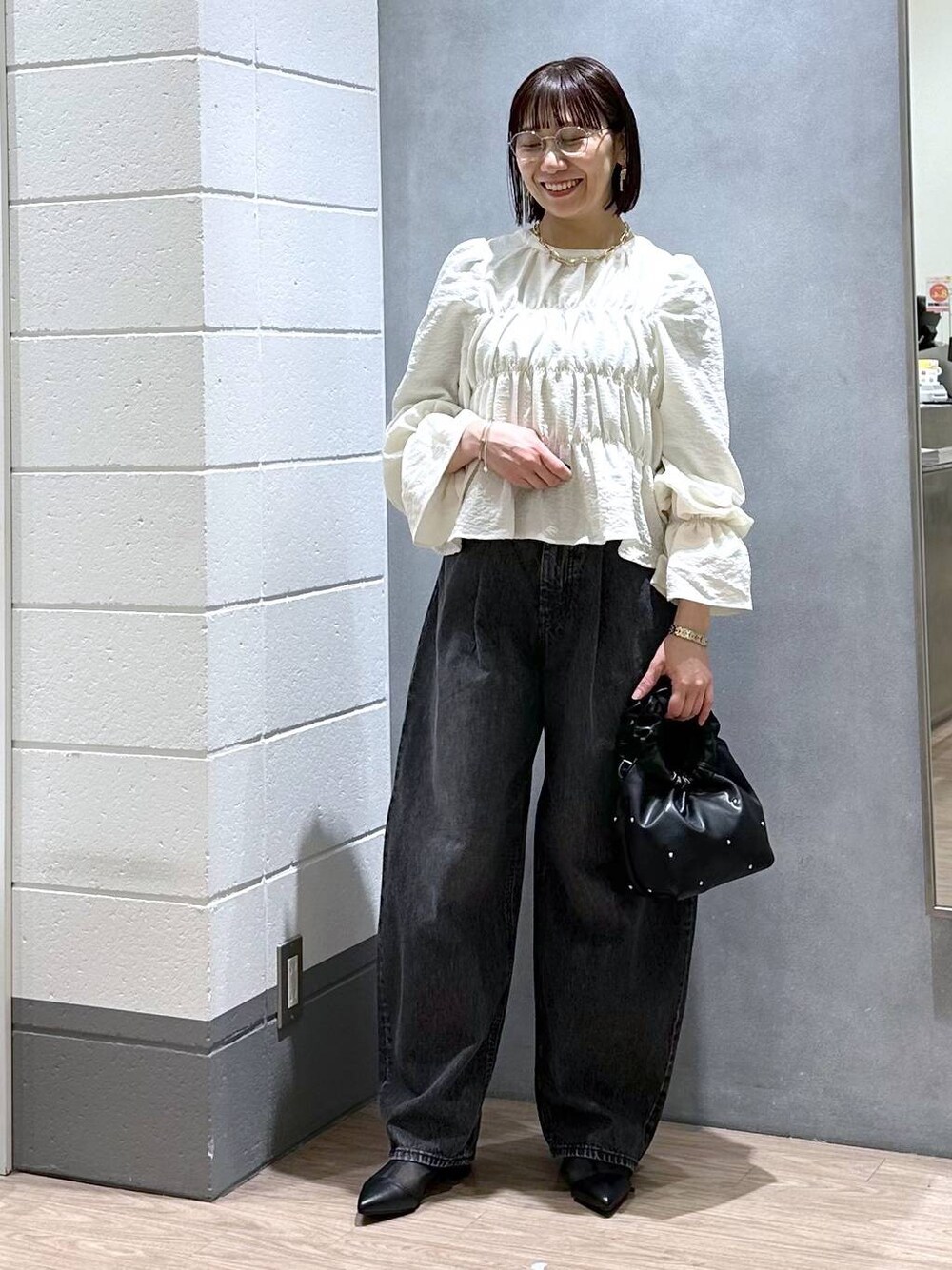 ブラック系のハンドバッグ、グリーン系のタンクトップ、ホワイト系のシャツ/ブラウスを着用したレディースの春コーディネートの1枚目の写真