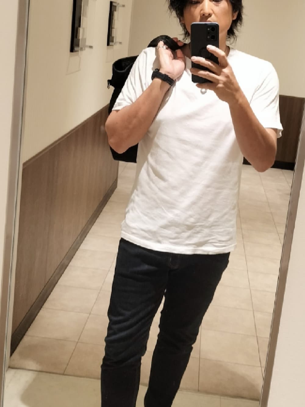 ホワイト系のTシャツ/カットソー、ブルー系のデニムパンツ、ブラック系のトートバッグを着用したメンズの夏コーディネートの1枚目の写真