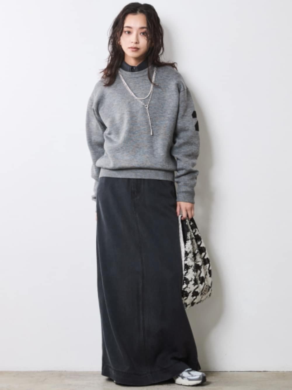 ブラック系のシャツ/ブラウス、ブラック系のデニムスカート、グレー系のニット/セーターを着用したレディースの秋コーディネートの1枚目の写真
