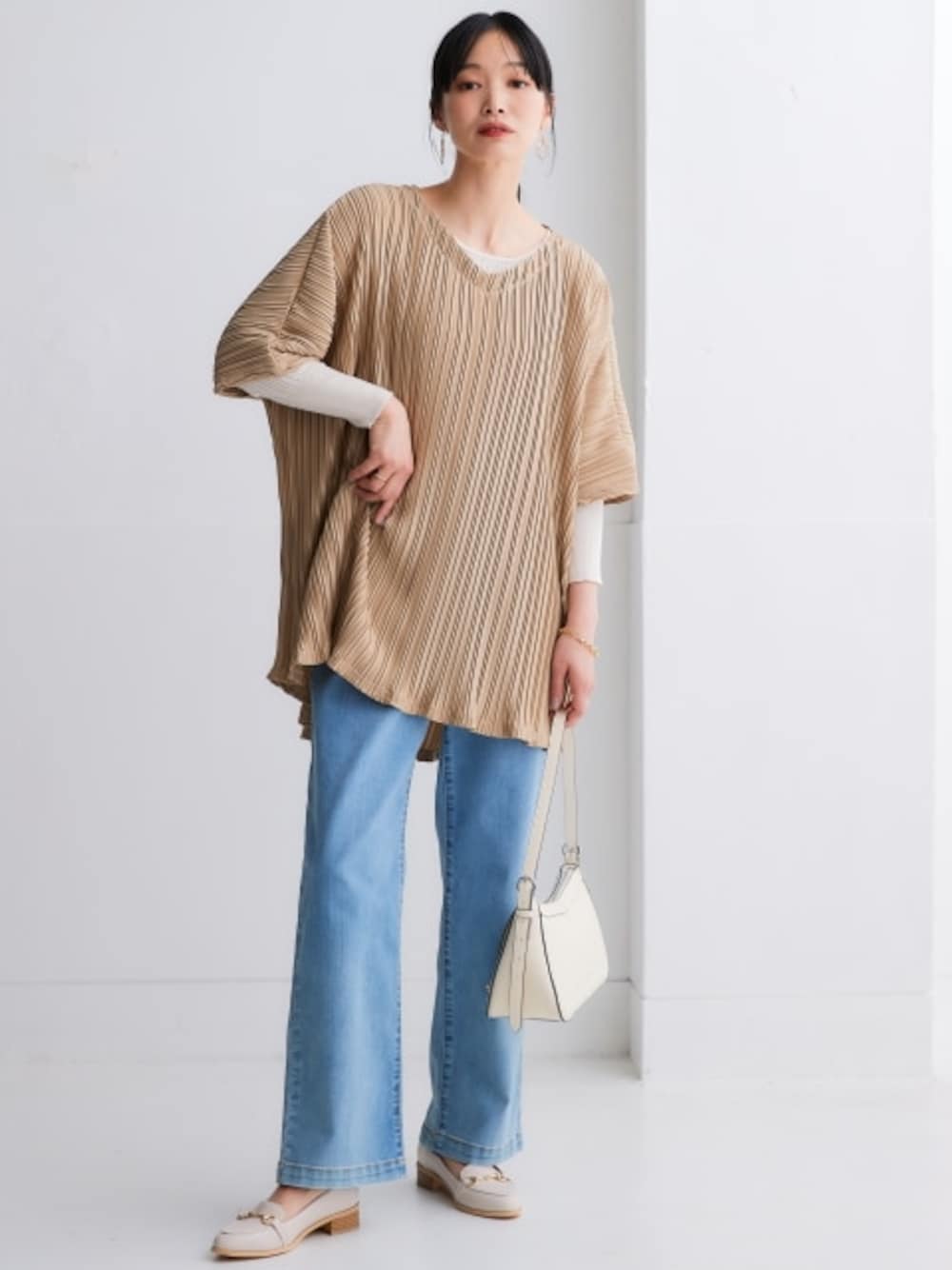 ホワイト系のニット/セーター、ブルー系のパンツ、ベージュ系のチュニックを着用したレディースの夏コーディネートの1枚目の写真