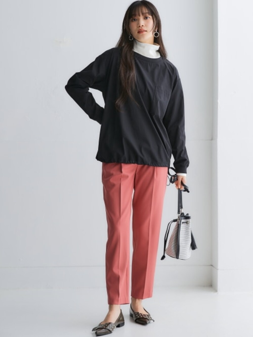 ピンク系のスラックス、ホワイト系のTシャツ/カットソー、ブラック系のシャツ/ブラウスを着用したレディースの冬コーディネートの1枚目の写真