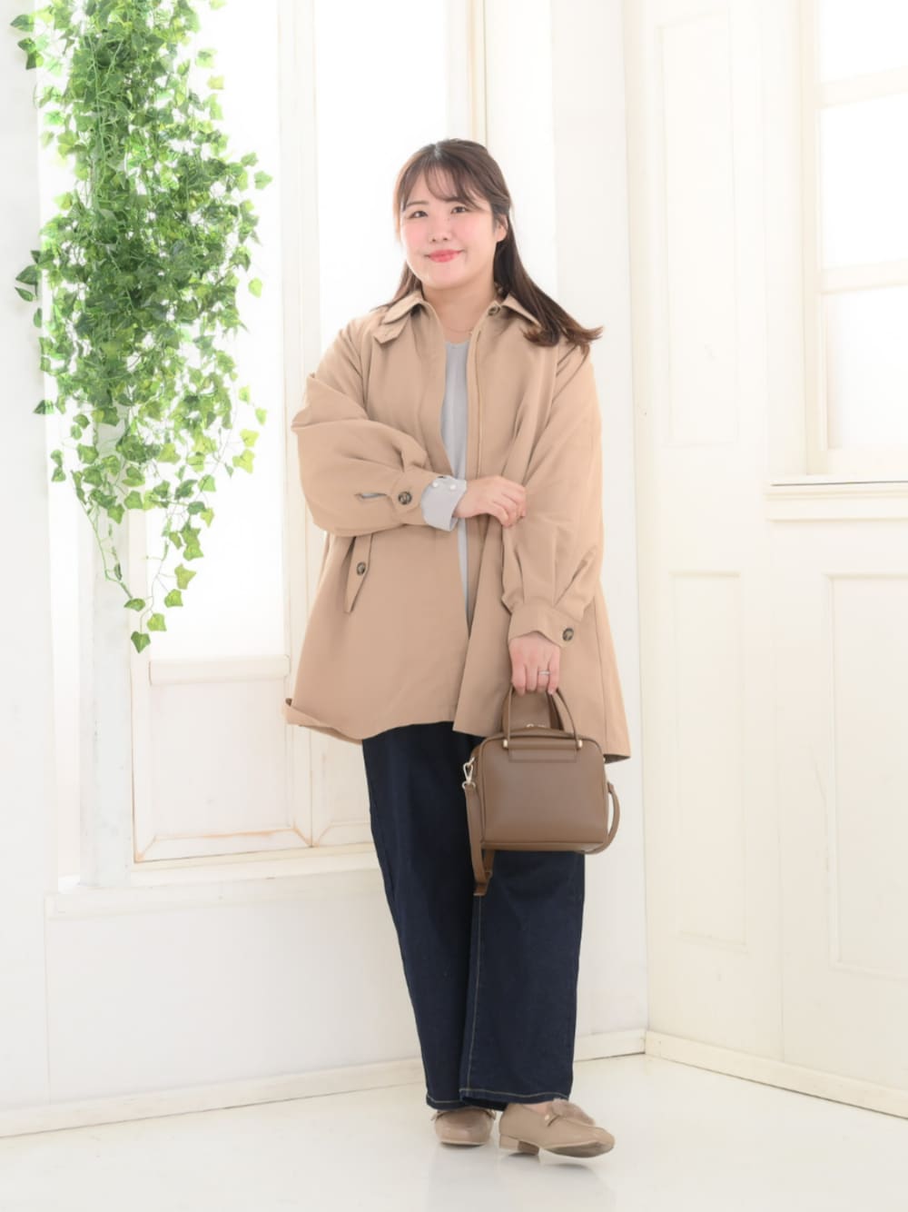 グレー系のTシャツ/カットソー、ブルー系のパンツ、ベージュ系のジャケット/アウターを着用したレディースの秋コーディネートの1枚目の写真