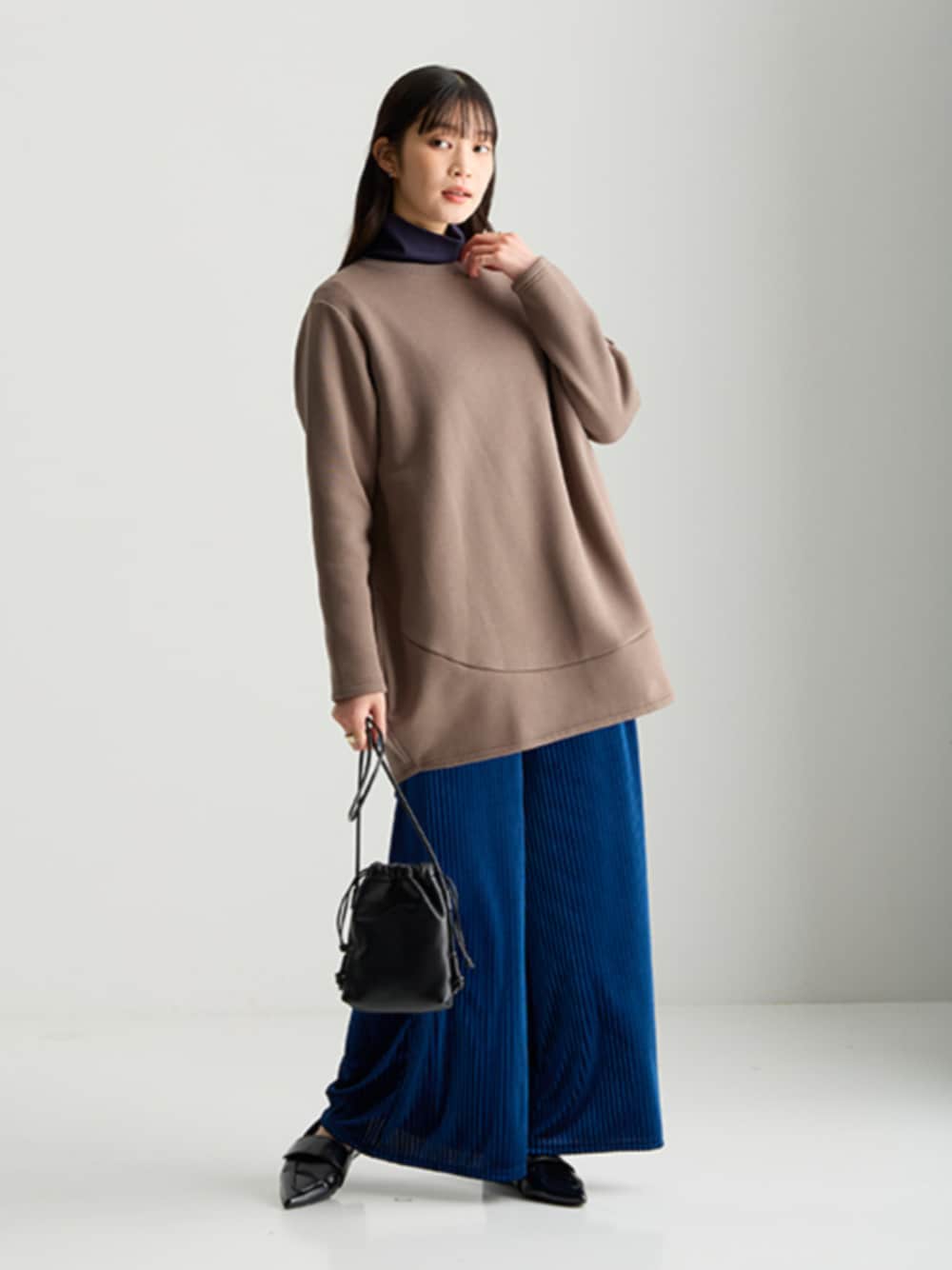 ブルー系のTシャツ/カットソー、ブラウン系のチュニック、ブルー系のパンツを着用したレディースの秋コーディネートの1枚目の写真