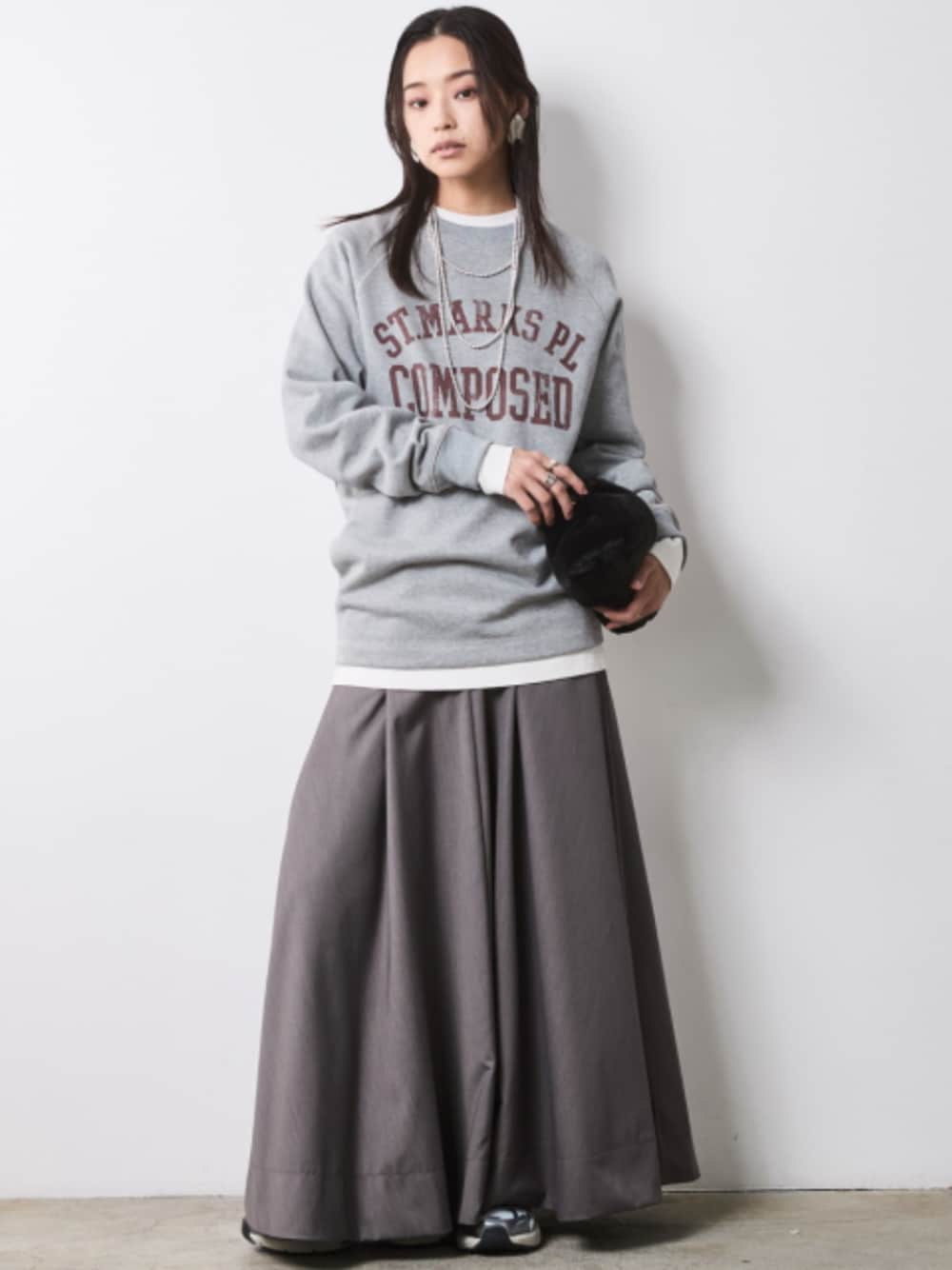 グレー系のスウェット、グレー系のスカートを着用したレディースの秋コーディネートの1枚目の写真