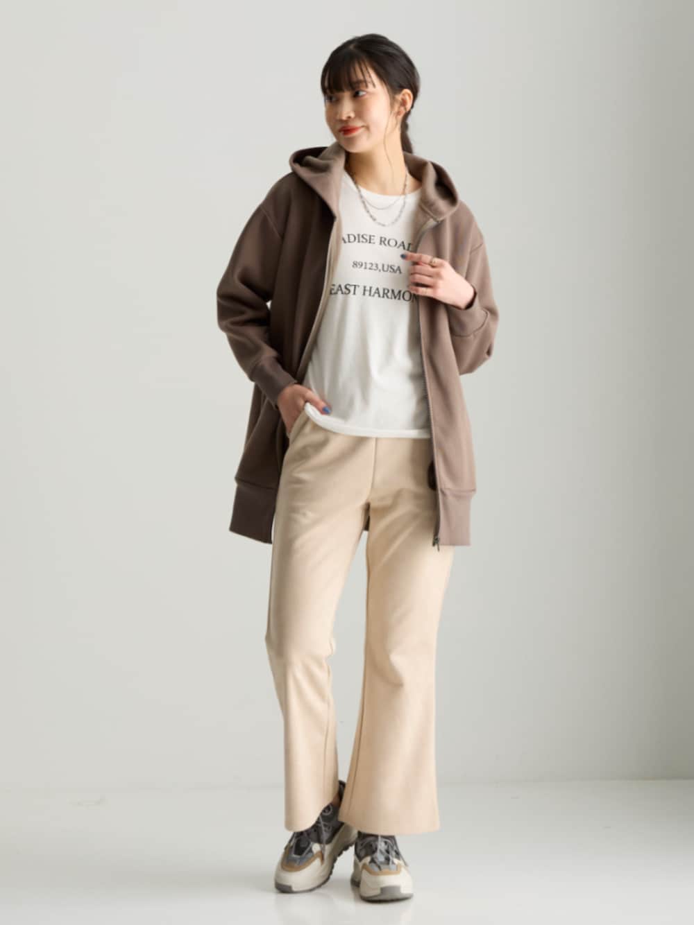 ブラック系のTシャツ/カットソー、ブラウン系のパーカー、ベージュ系のパンツを着用したレディースの秋コーディネートの1枚目の写真